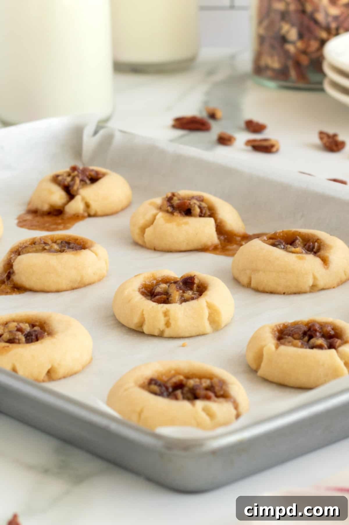 A close-up shot of a single Pecan Pie Thumbprint Cookie, showing its detailed texture and rich filling.