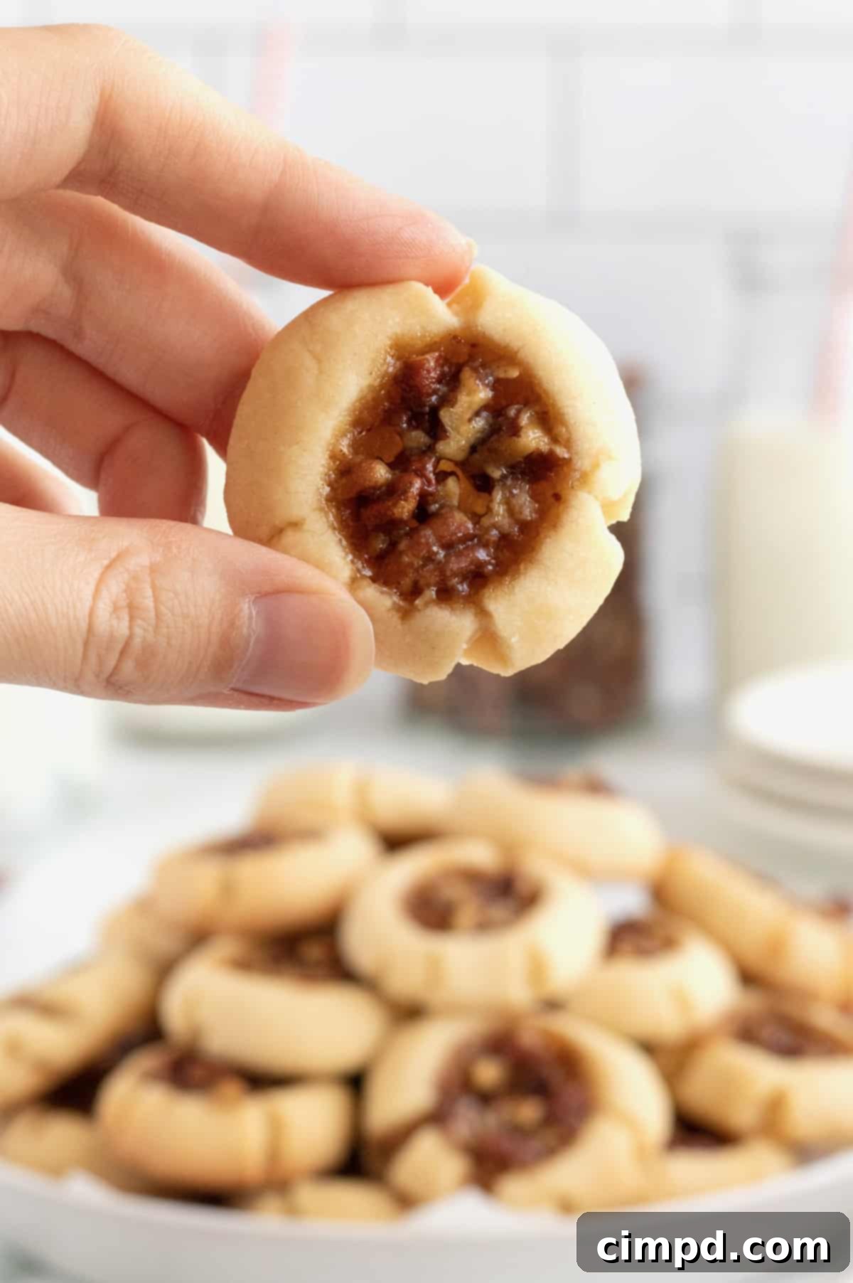 A stack of Pecan Pie Thumbprint Cookies, showcasing their rich texture and perfect golden-brown color, ready for storage.