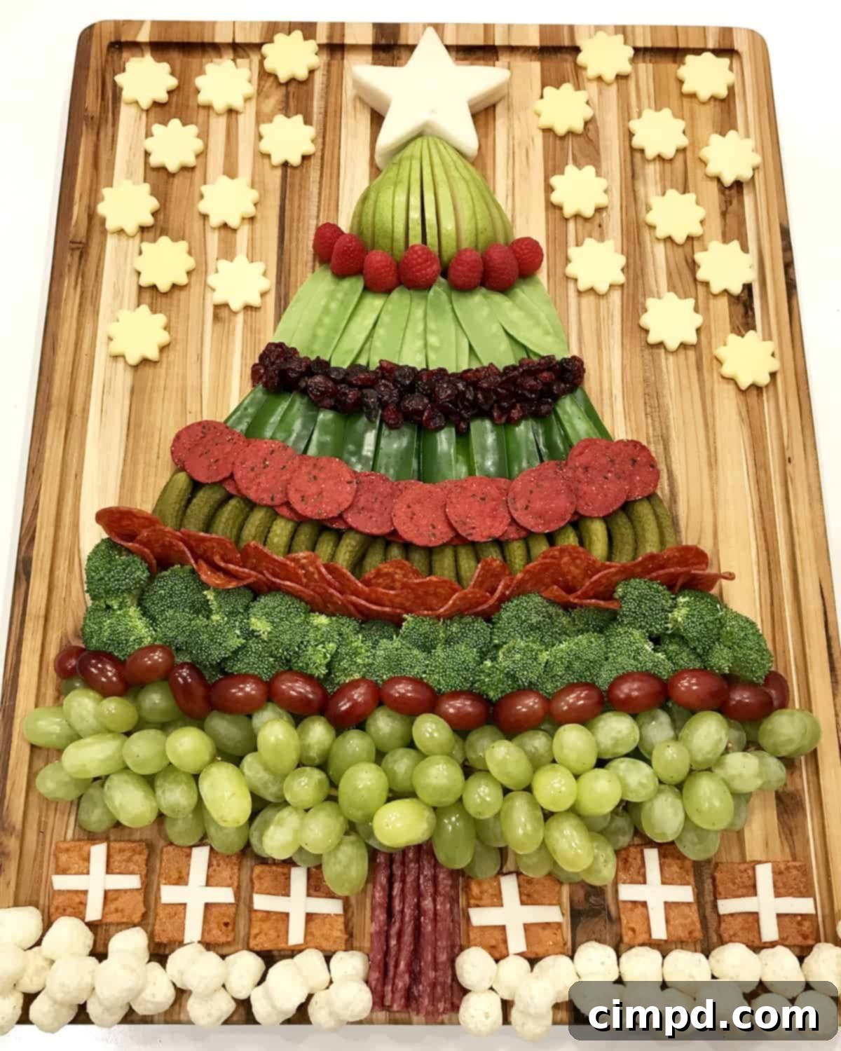 Holiday Tree of Treats 2 A vibrant close-up of the Christmas Tree Snack Board, showcasing the fresh green, red, and white fruits, vegetables, and cheeses arranged in a delightful holiday pattern.