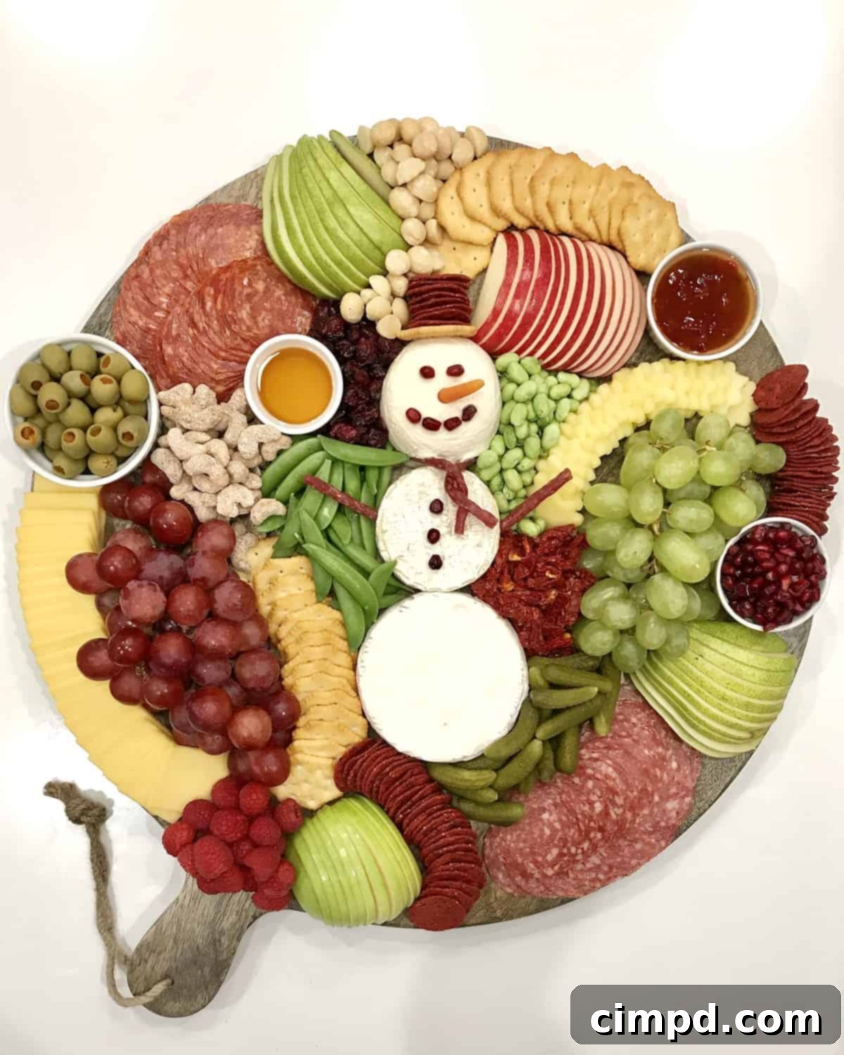 The finished Snowman Snack Board by The BakerMama, loaded with festive red, green, and white treats.