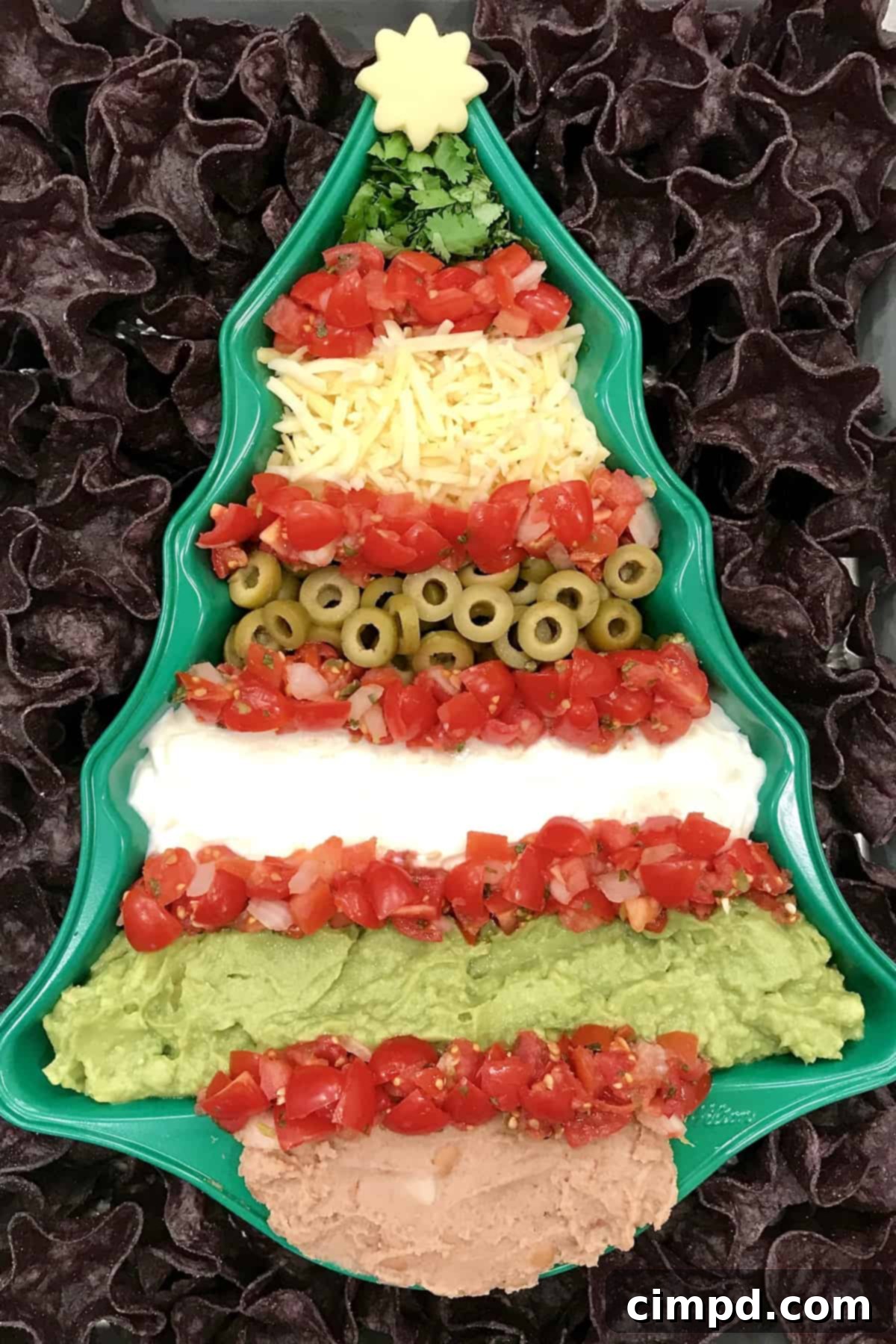 Close-up of Christmas Tree 7 Layer Dip, showcasing the delicious layers by The BakerMama