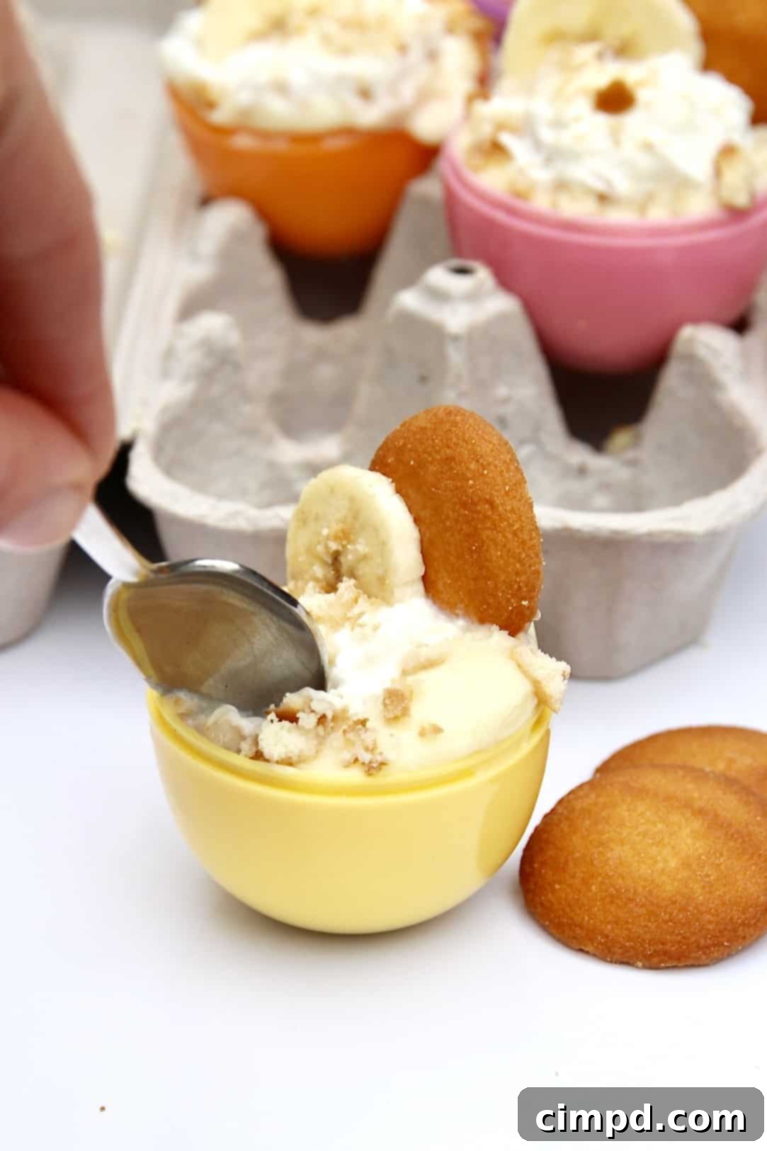 A tray of fully assembled Easter Egg Banana Pudding Cups, garnished with wafers and banana slices, ready to be served.