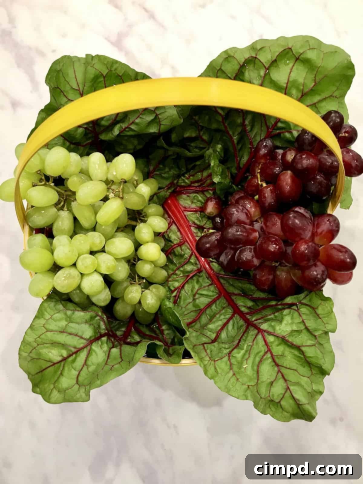 Placing red grapes in the Easter Snack Basket for a colorful arrangement