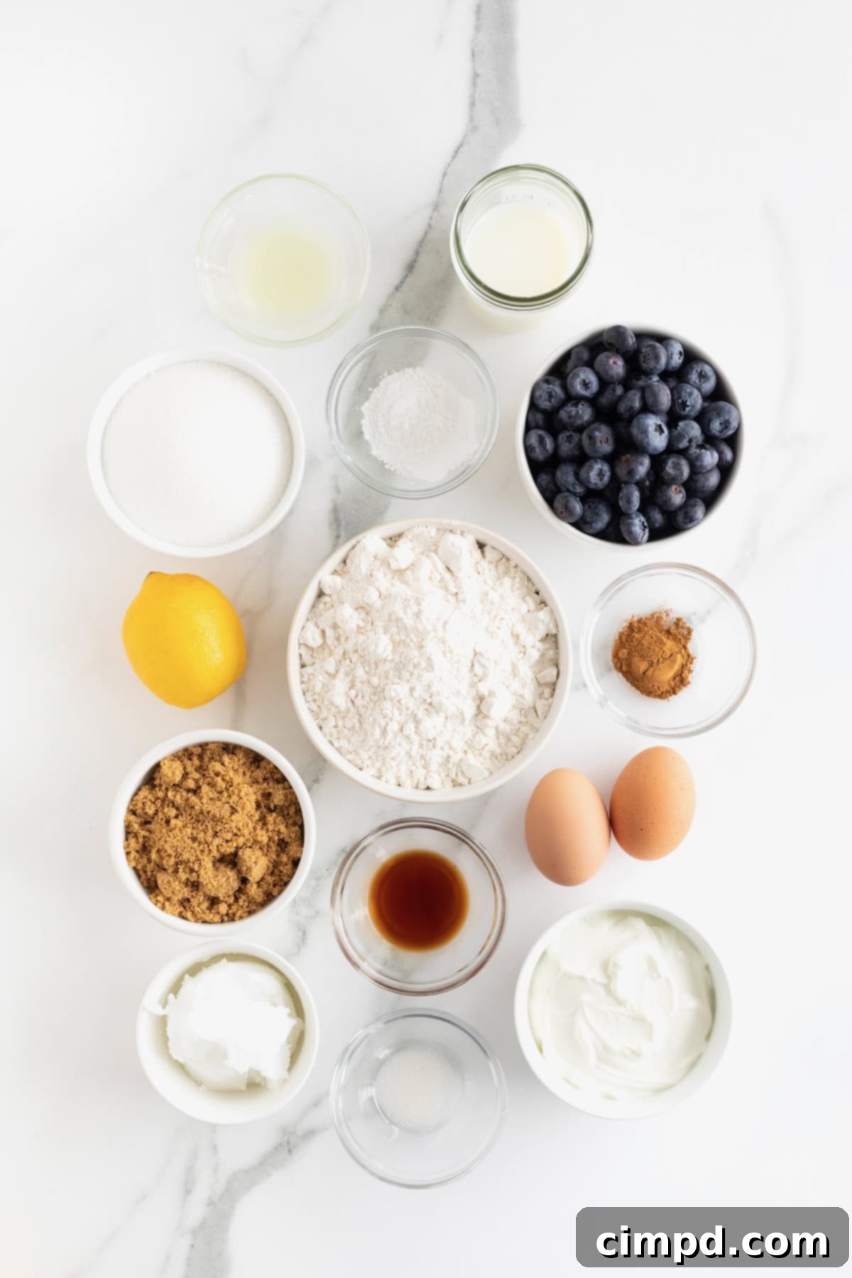 Blueberry Burst Greek Yogurt Crumb Cake 6 Ingredients for Greek Yogurt Blueberry Coffee Cake in small glass dishes on a white marble counter.