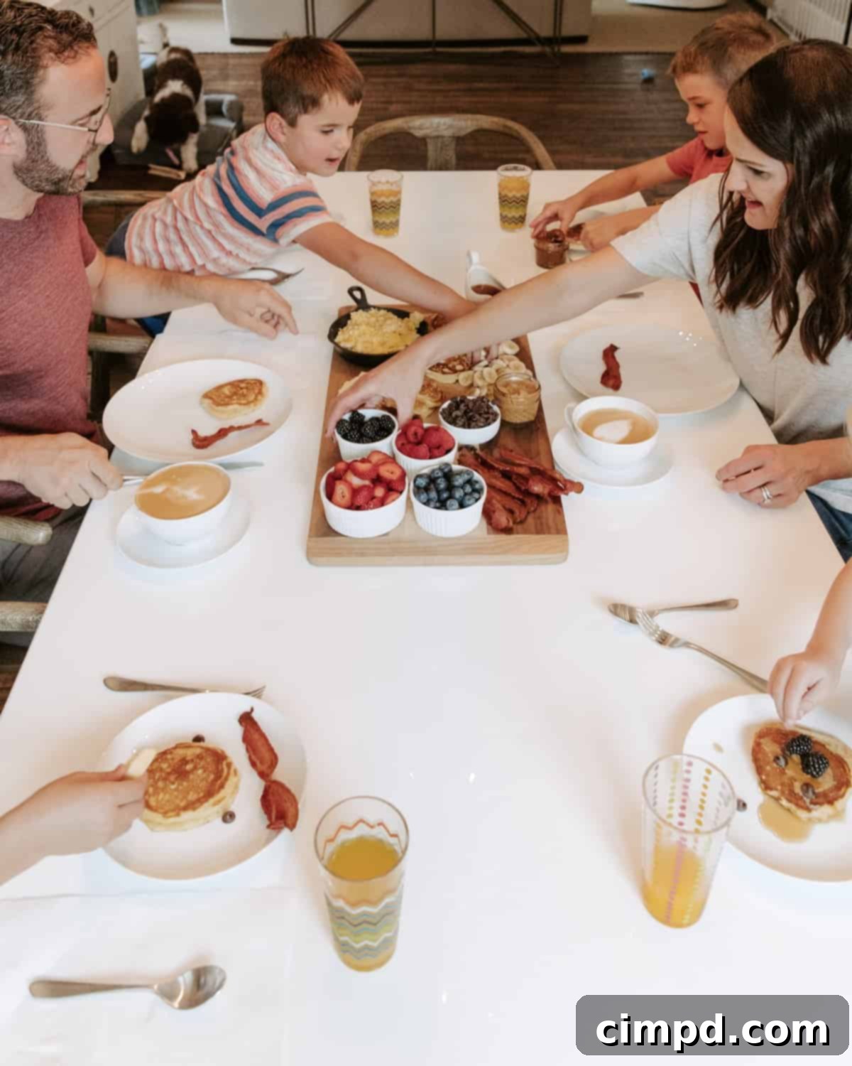 Child thoughtfully selecting items from a breakfast board for their plate