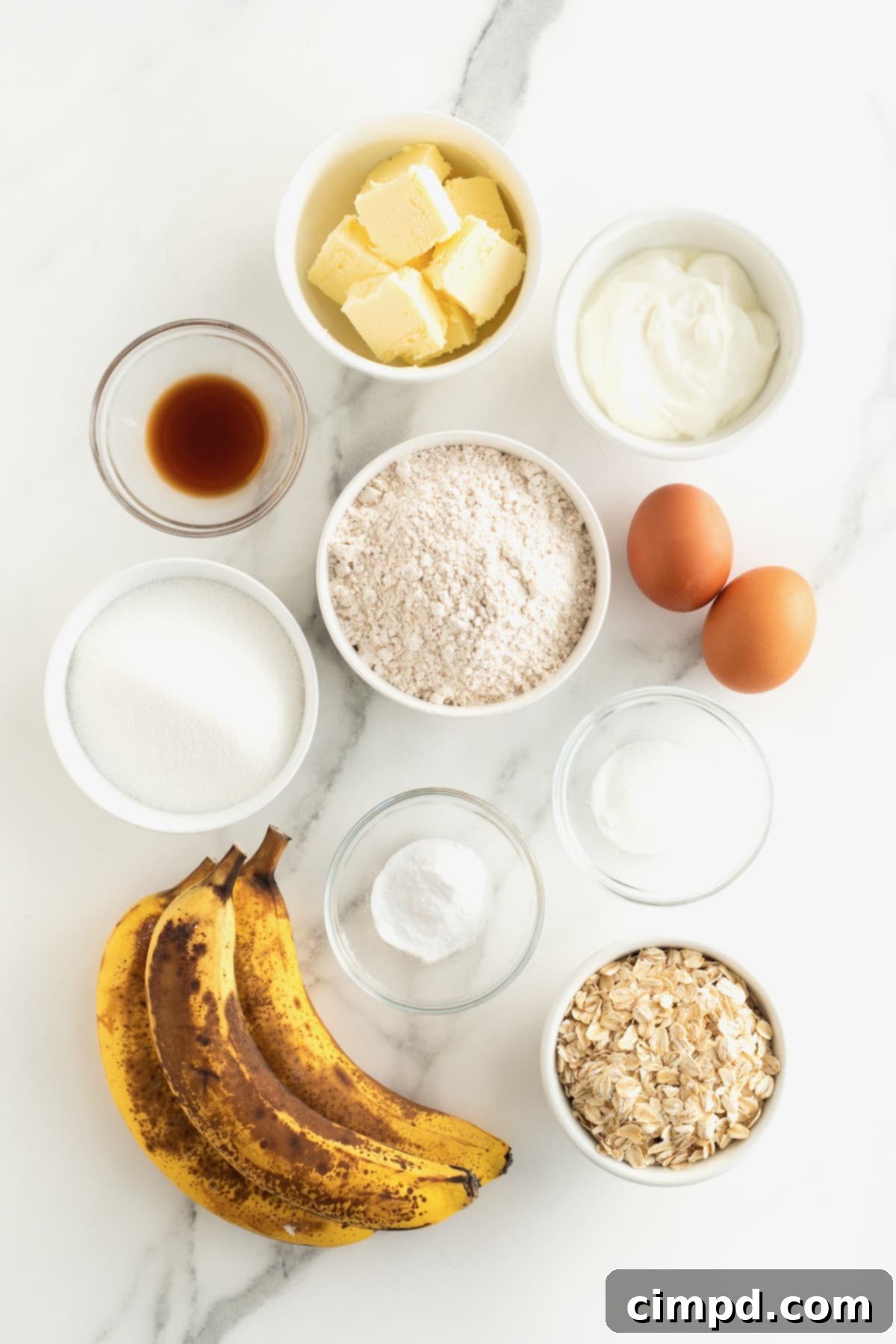 Banana Oat Whole Wheat Bread 5 Ingredients for Whole Wheat Banana Oat bread in small glass dishes on white marble counter.