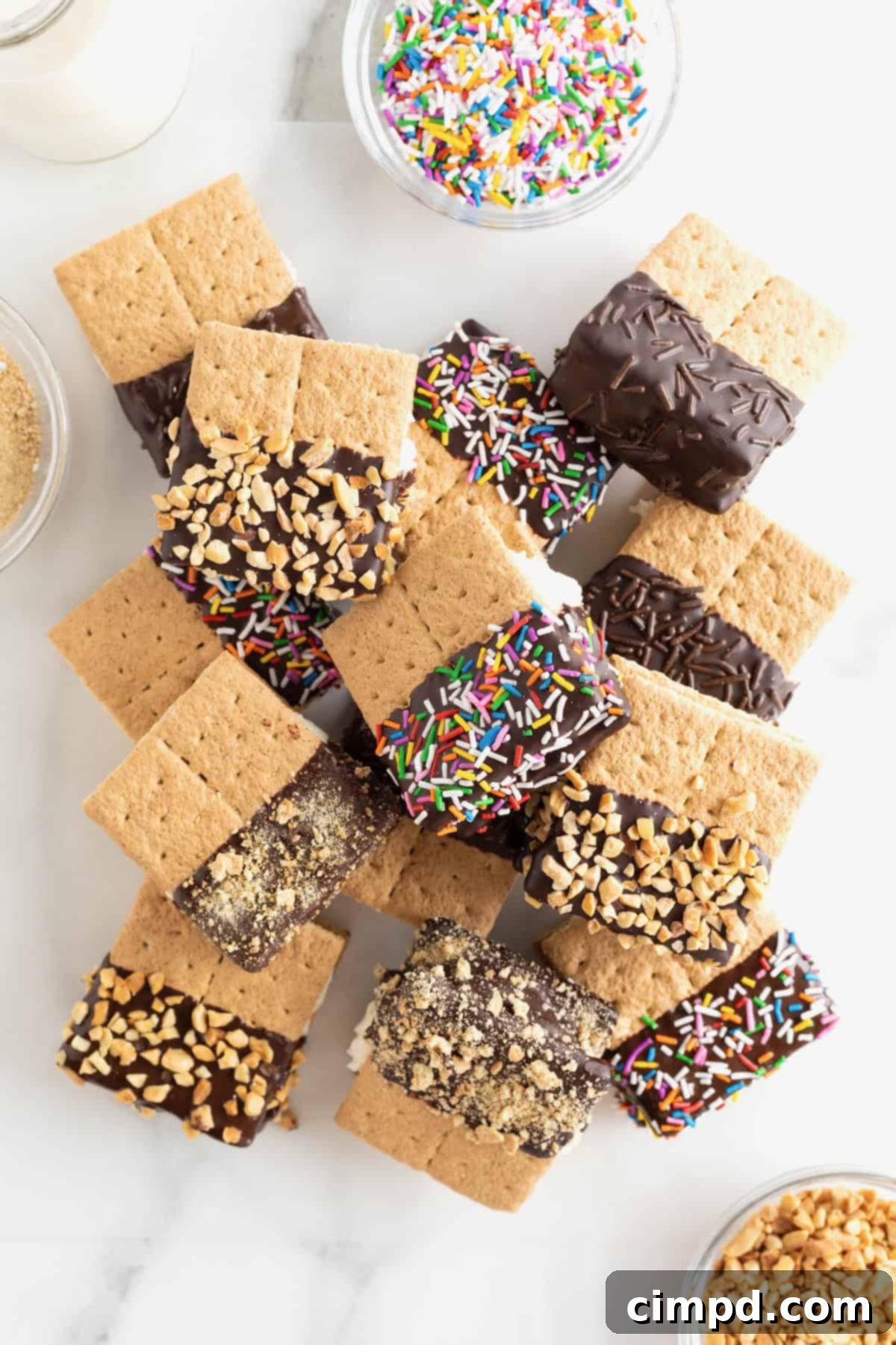 A pile of graham cracker ice cream sandwiches that have been dipped halfway in chocolate. 