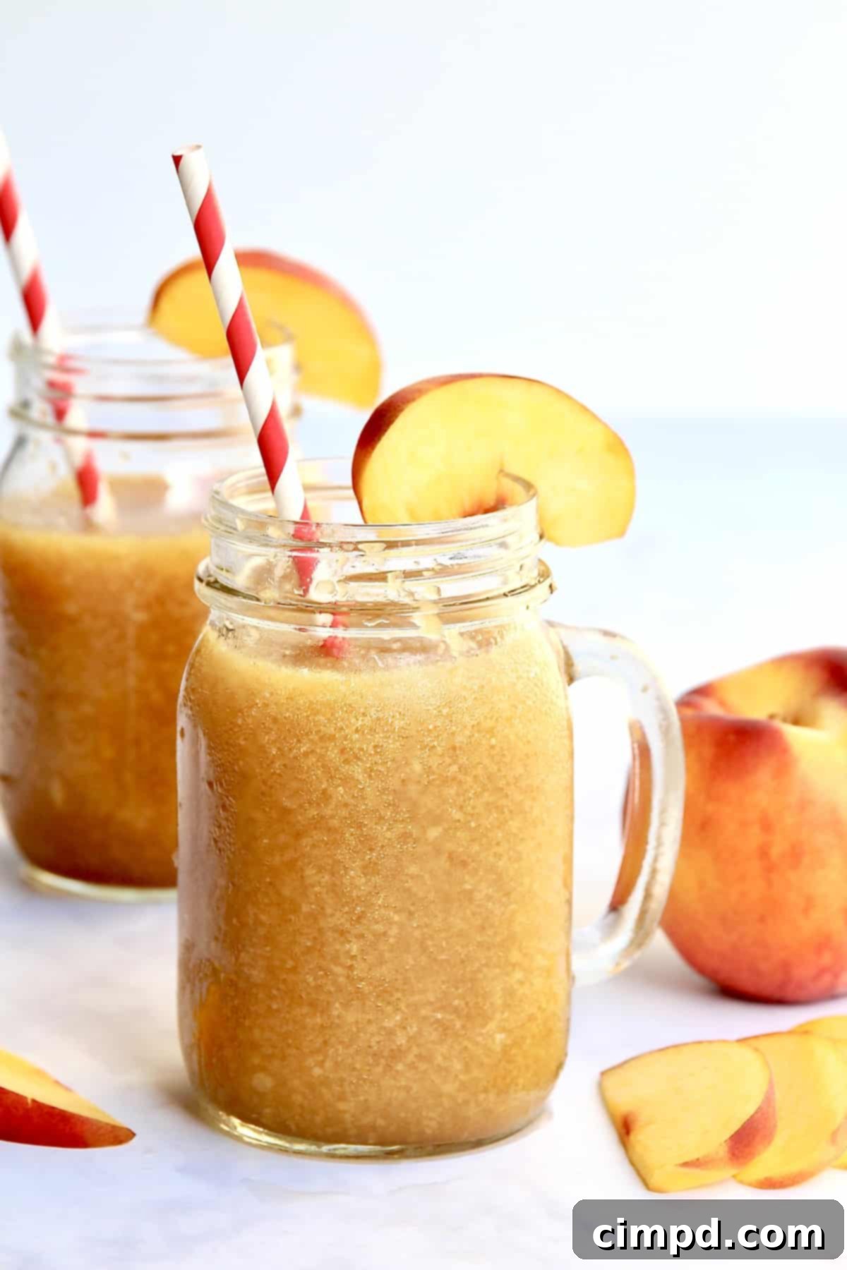 Frozen Peach Tea Bliss 2 Delicious Peach Tea Slushie served in a glass with peach slices, perfect for summer.
