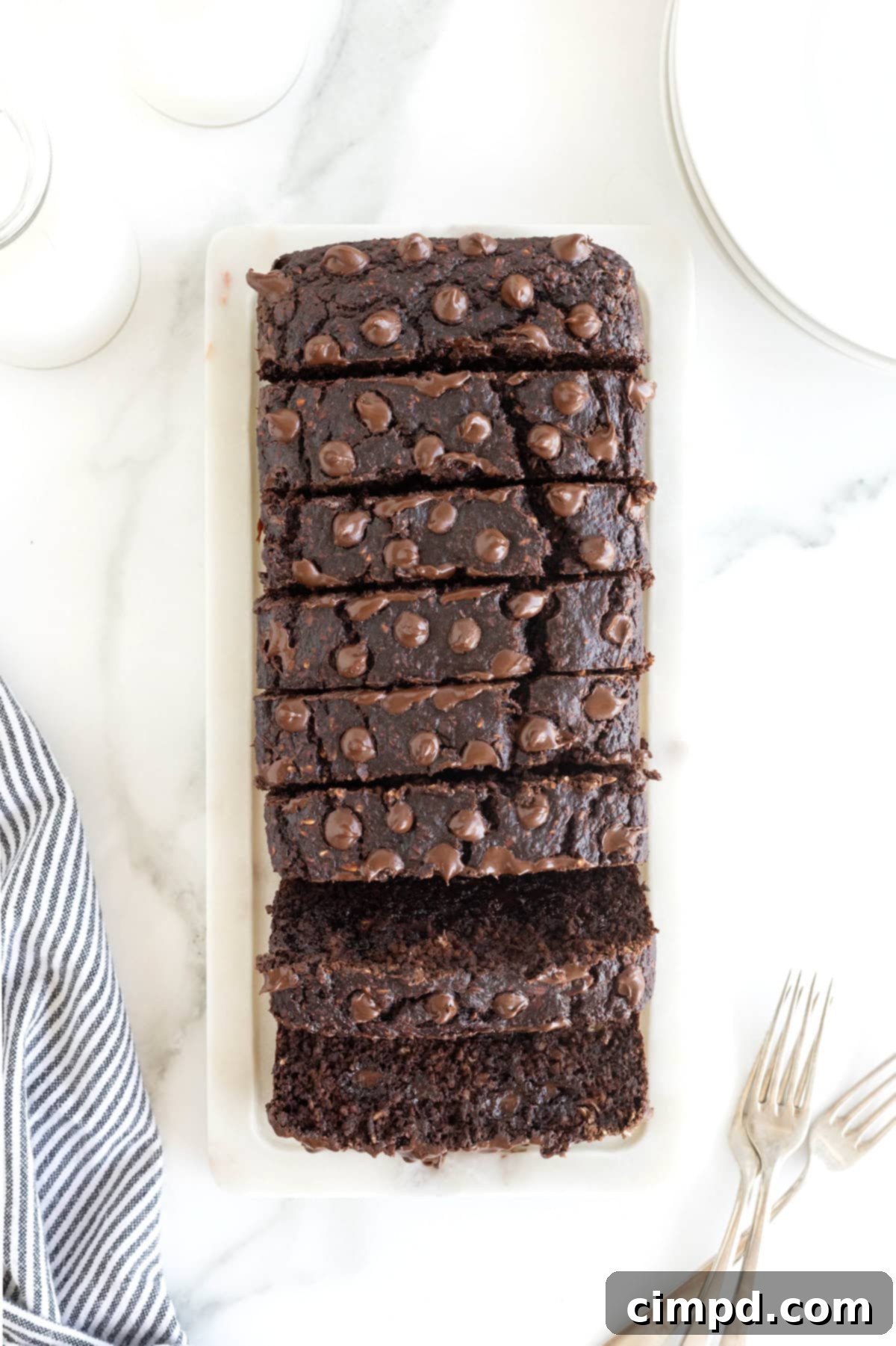 An overhead view of a freshly baked Flourless Chocolate Banana Bread, neatly sliced into eight inviting portions, ready to be served and enjoyed.