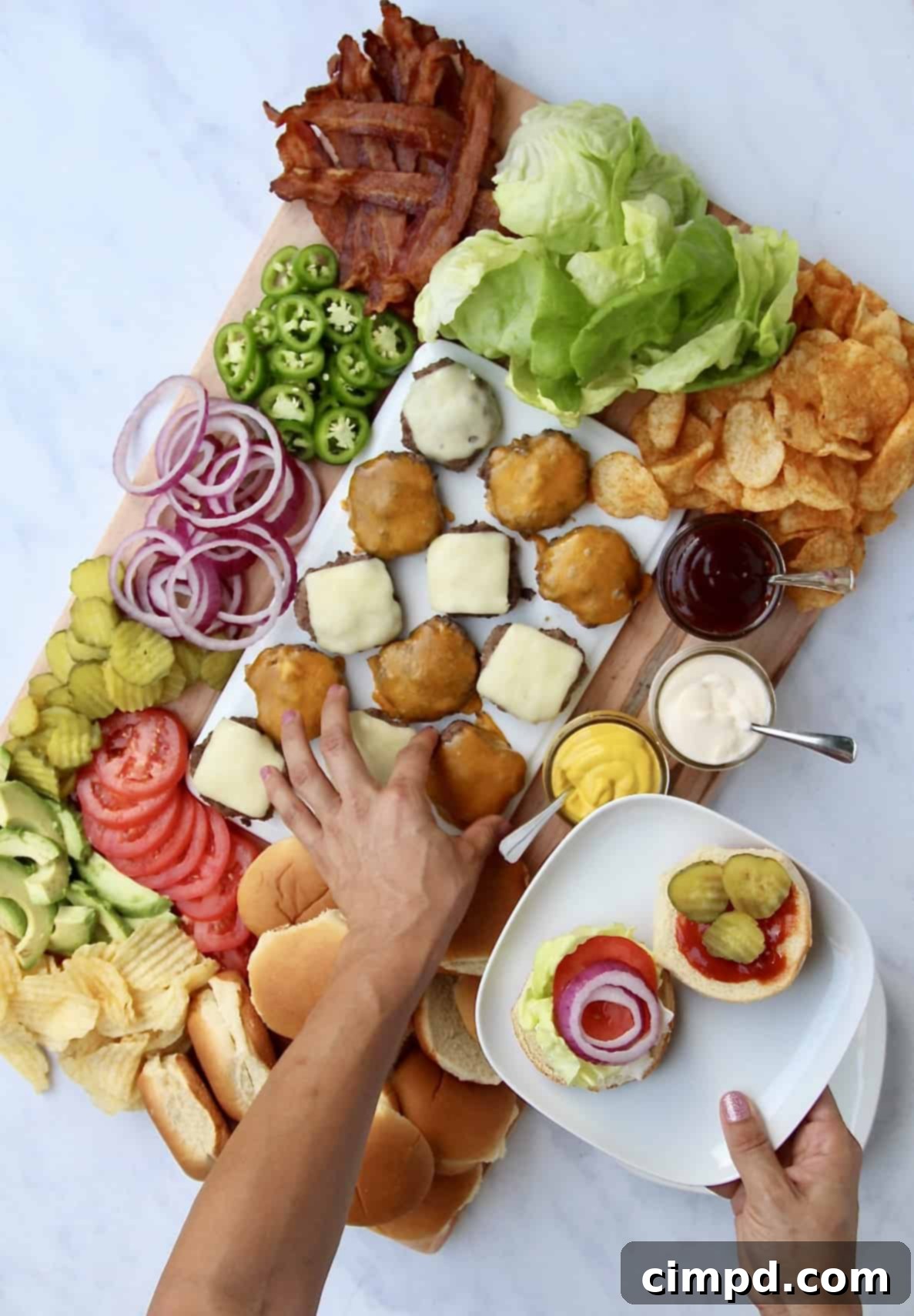 A close-up view of a Build-Your-Own Burger Board showcasing neatly arranged ingredients like cheese, pickles, and sauces, inviting guests to customize.