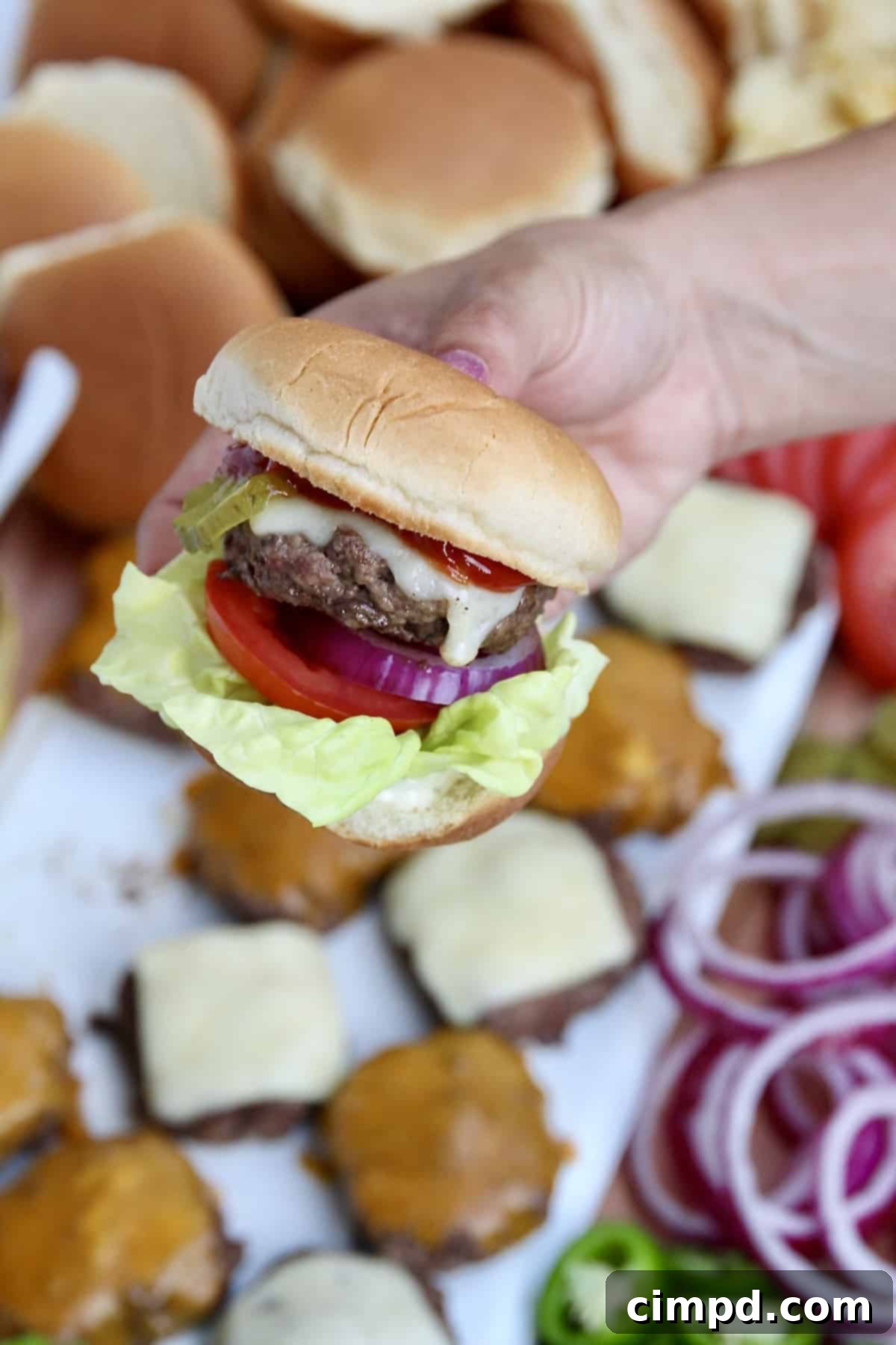 A beautifully arranged Build-Your-Own Burger Board by The BakerMama, featuring an abundance of burger components like various buns, fresh vegetables, and condiments.