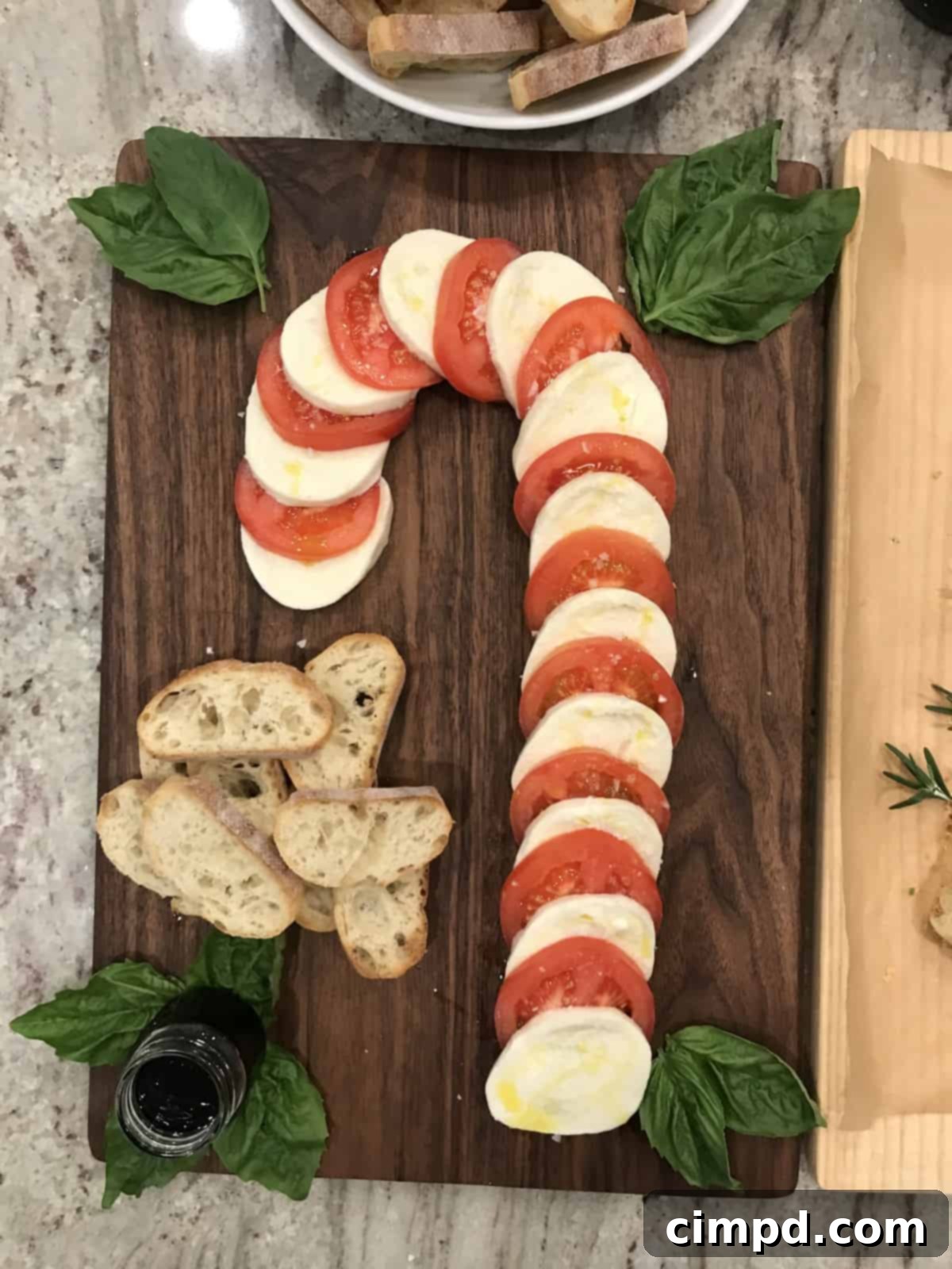 Crimson & Snow Caprese Board 3 Close-up of the perfectly arranged Candy Cane Caprese Board ingredients with basil and olive oil