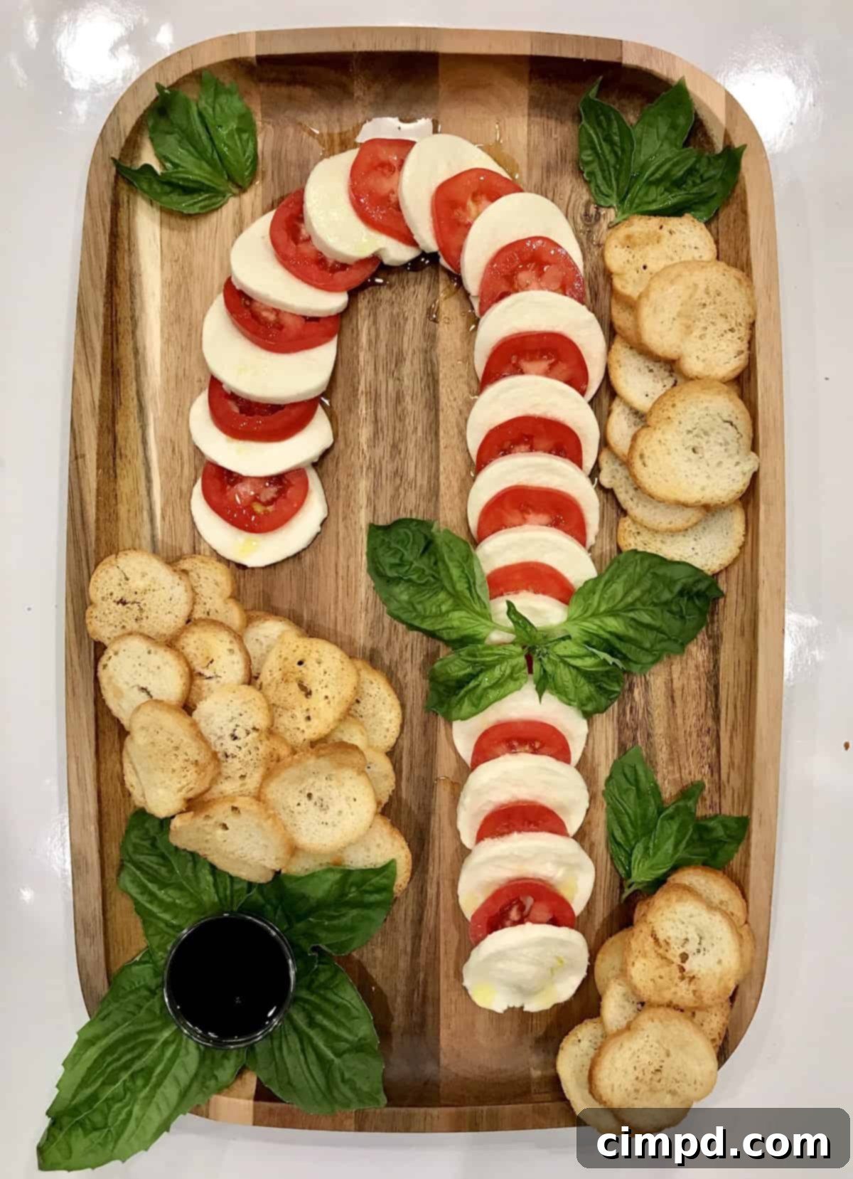 Crimson & Snow Caprese Board 4 Beautifully garnished Candy Cane Caprese Board ready for festive guests with fresh basil and olive oil