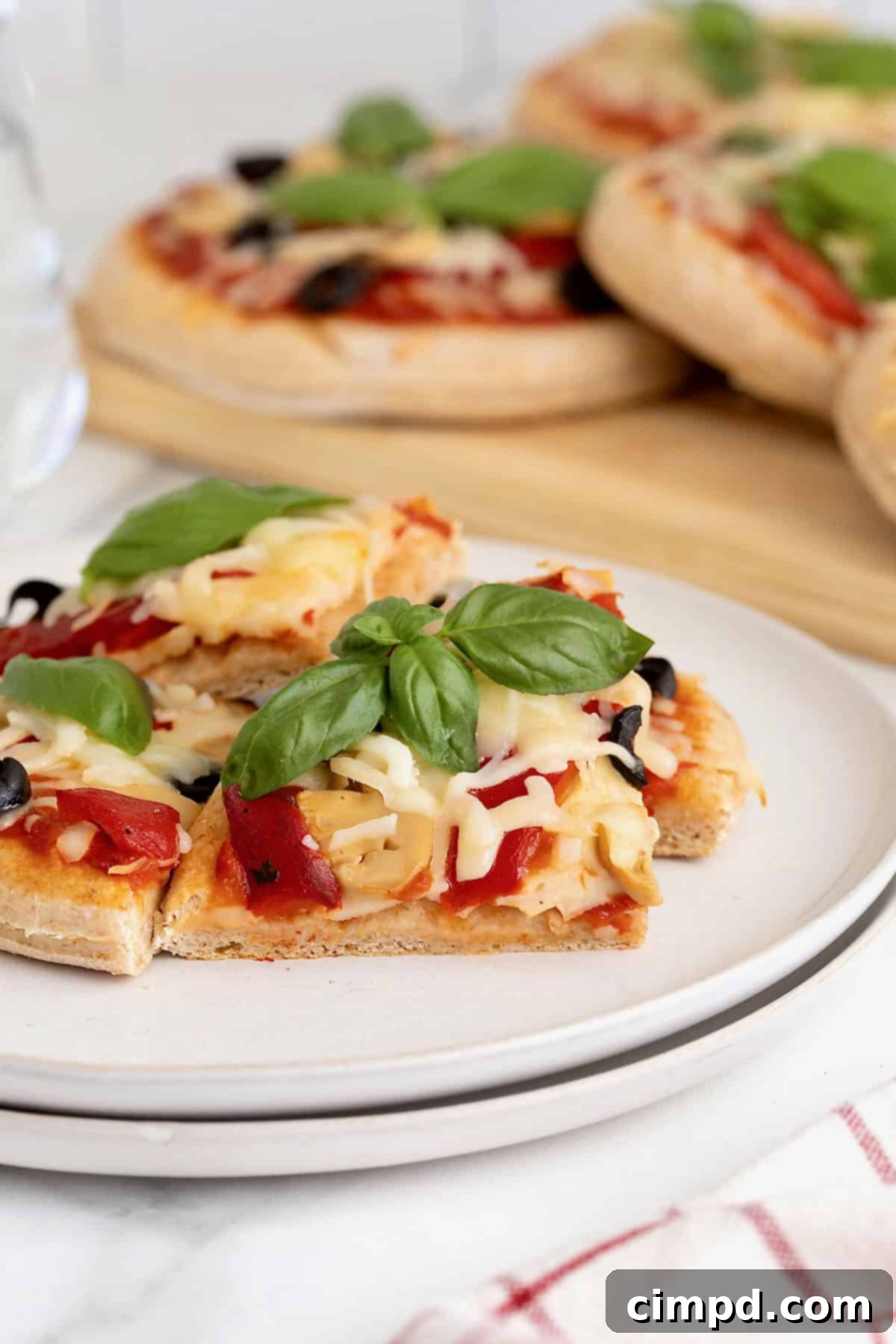 Close-up of golden, baked slices of whole wheat Greek yogurt pizza on a small white plate, ready to be enjoyed.