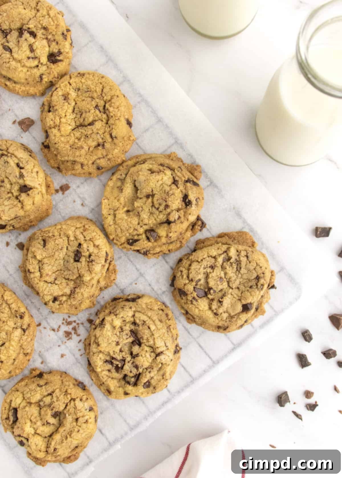 Freshly baked chocolate chip cookies cooling on a wire rack, steam gently rising.