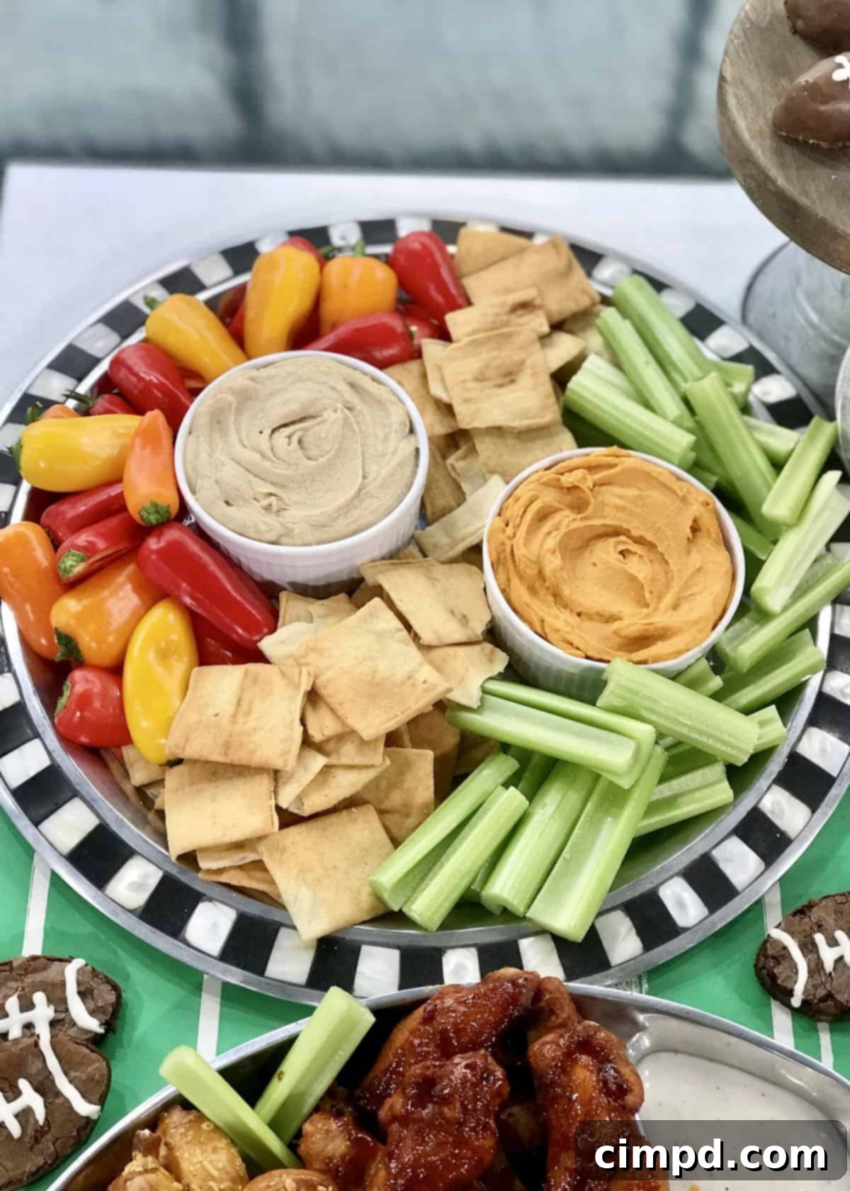 The Ultimate Super Bowl Spread - A colorful Hummus Tray with various vegetables and crackers for dipping.
