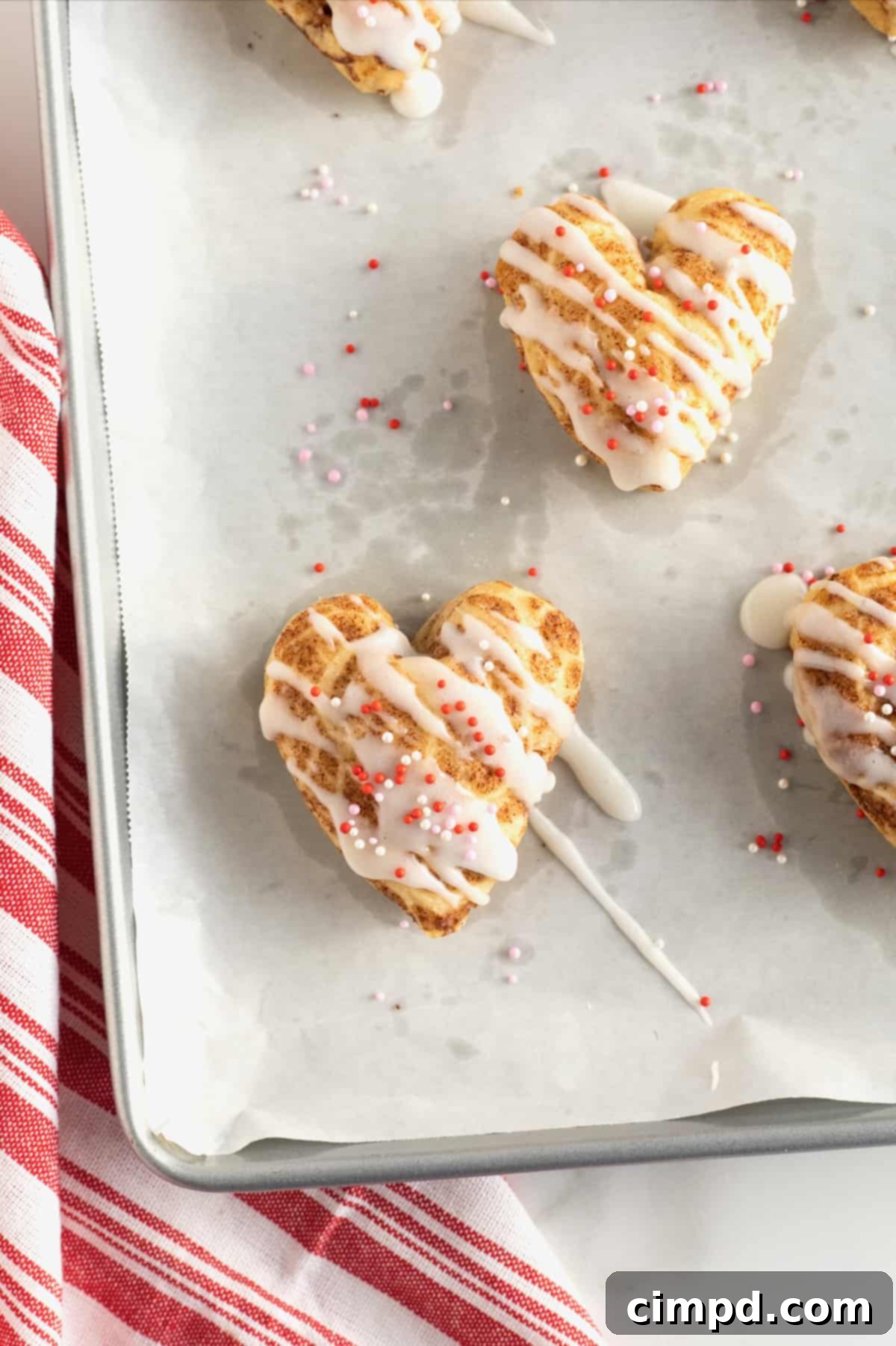 Sweetheart Swirls 3 Close-up of freshly baked heart-shaped cinnamon rolls on a tray