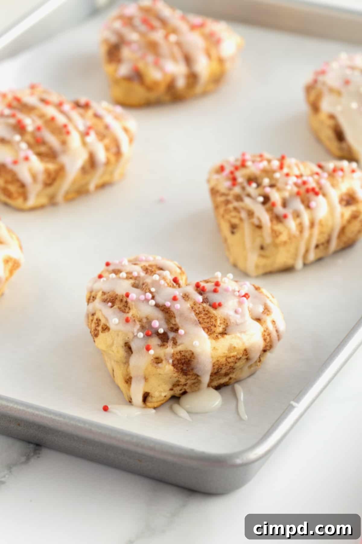 Sweetheart Swirls 8 Heart-shaped cinnamon rolls presented on a wooden board