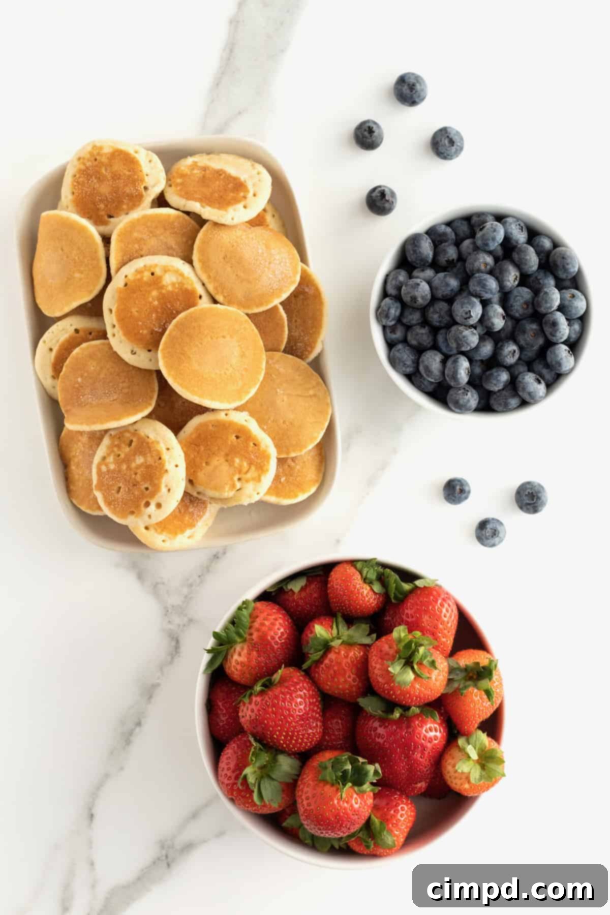 Cupid's Pancake Skewers 7 Ingredients laid out for Cupid's Pancake Kabobs: pancakes, strawberries, blueberries, cookie cutters, skewers