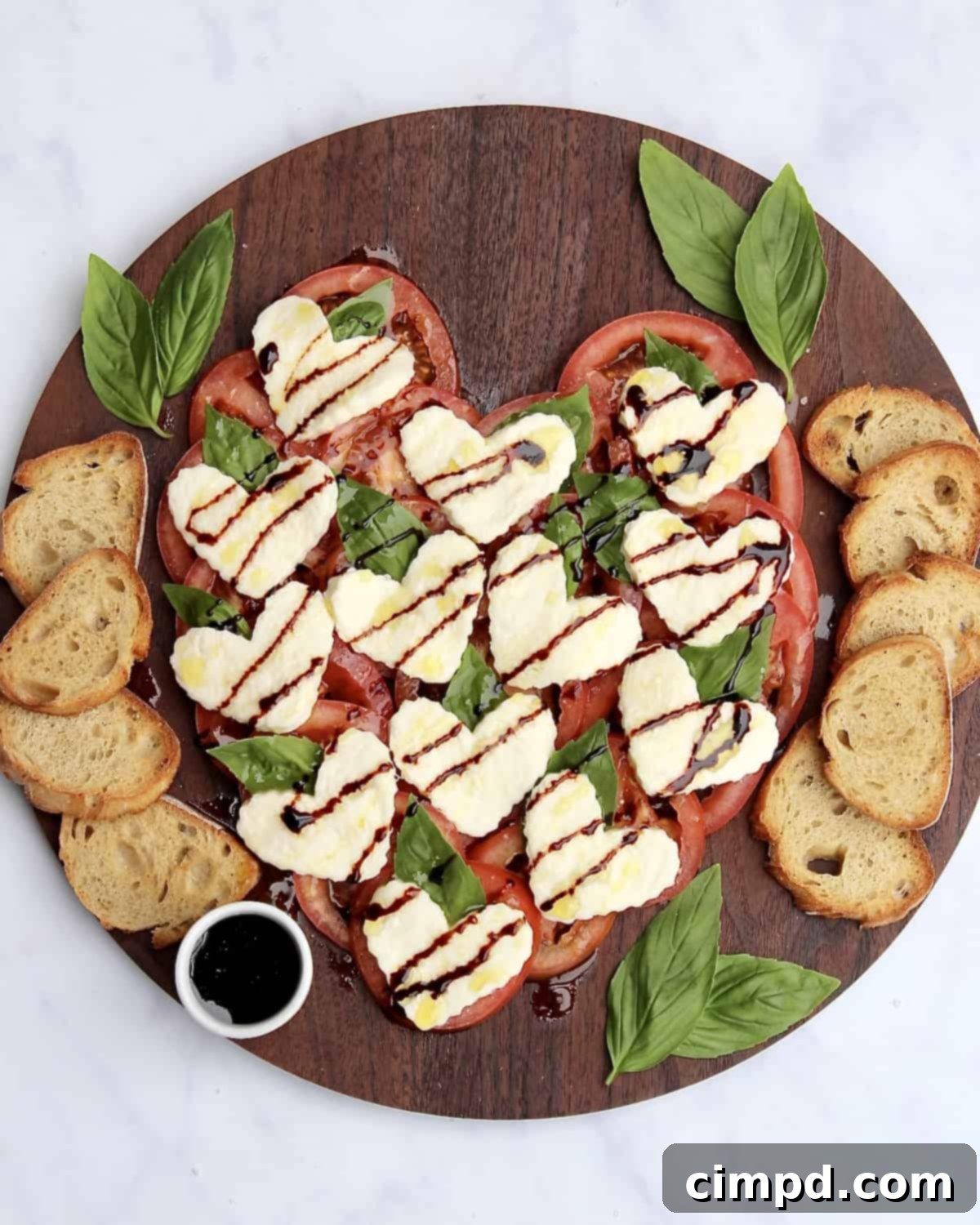 Caprese Hearts 2 Heart Caprese Salad, beautifully arranged with tomatoes, mozzarella, and basil in a heart shape.