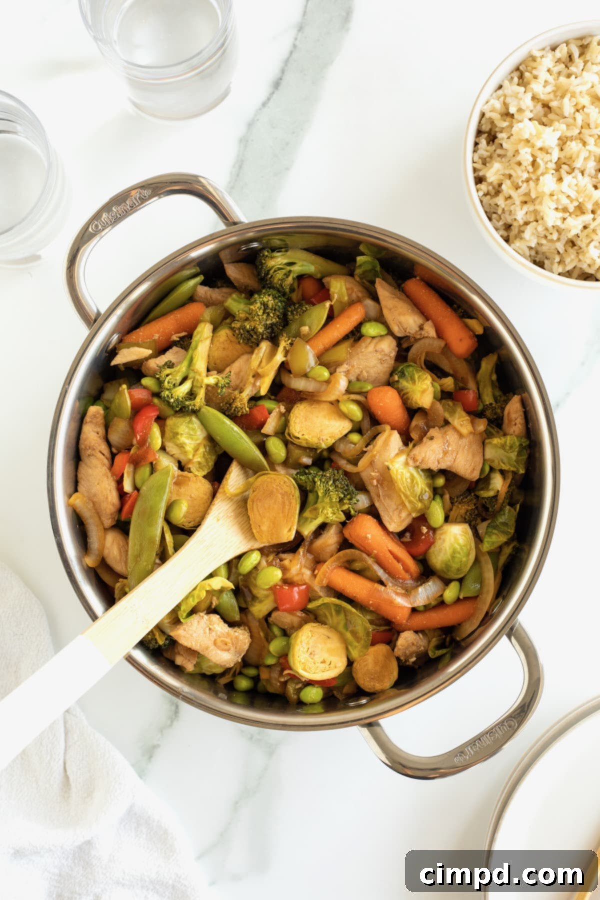 A steaming wok filled with expertly stir-fried chicken and a medley of colorful vegetables, coated in a luscious sweet and spicy sauce.