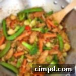 A top-down view of a delicious Sweet and Spicy Stir Fry with chicken and vegetables, served over rice.