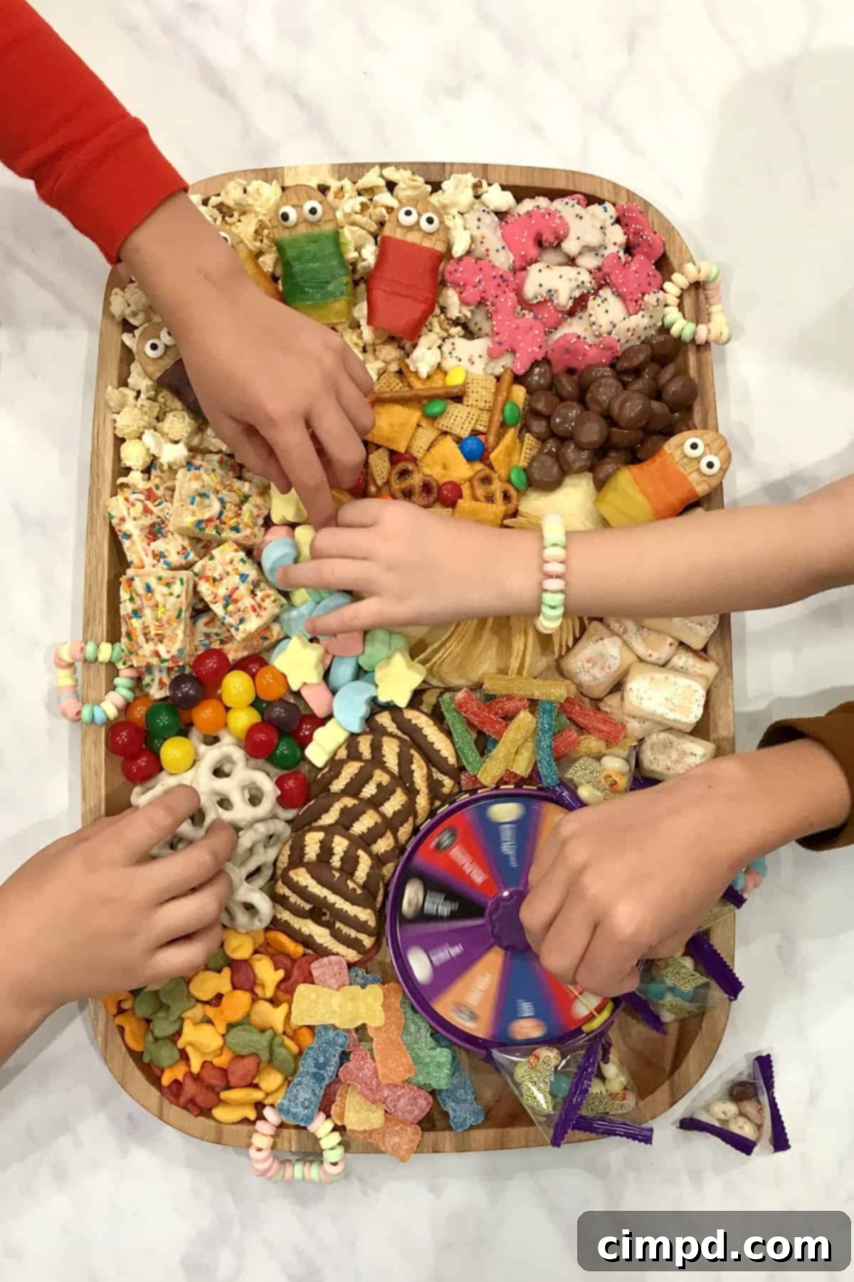 Close-up of a Nutter Butter cookie decorated to look like a sleeping bag friend with candy eyes and a Fruit by the Foot wrapper.