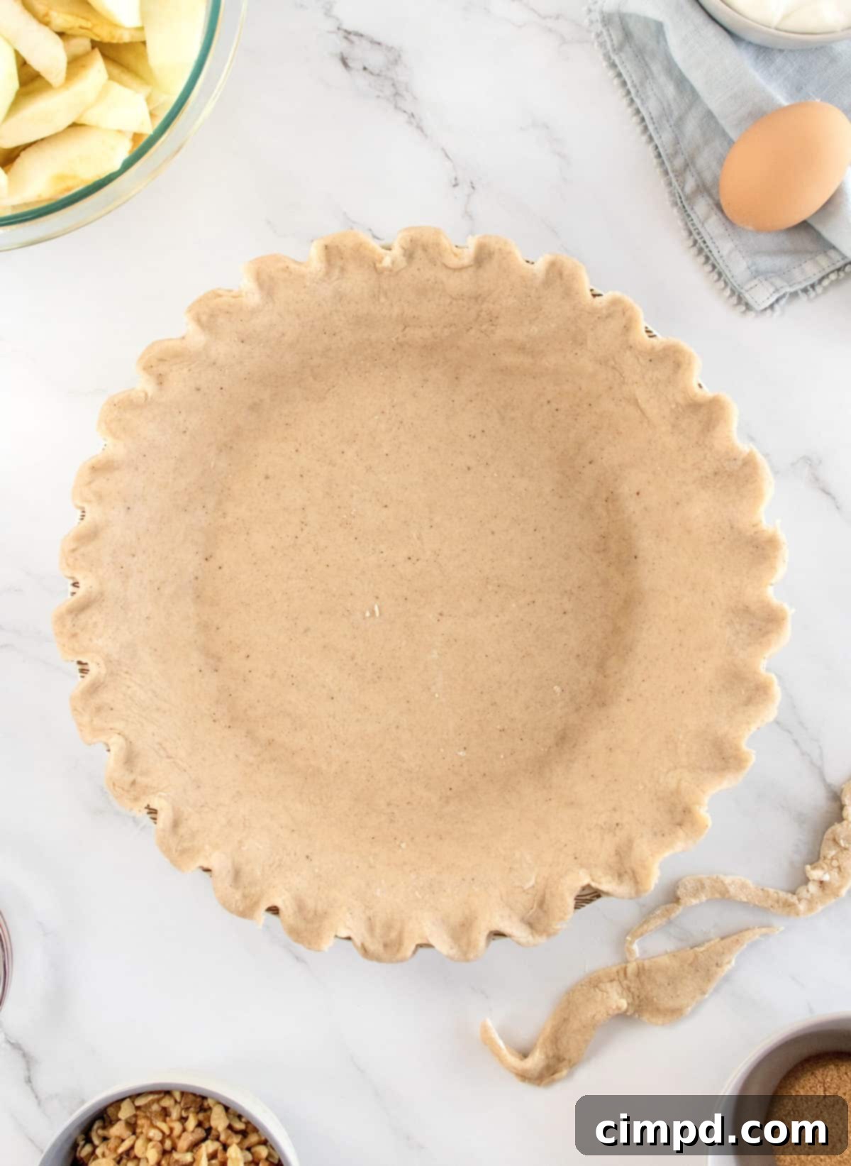 Mom's Signature Apple Pie 5 The pie crust being carefully placed into a 10-inch pie plate.