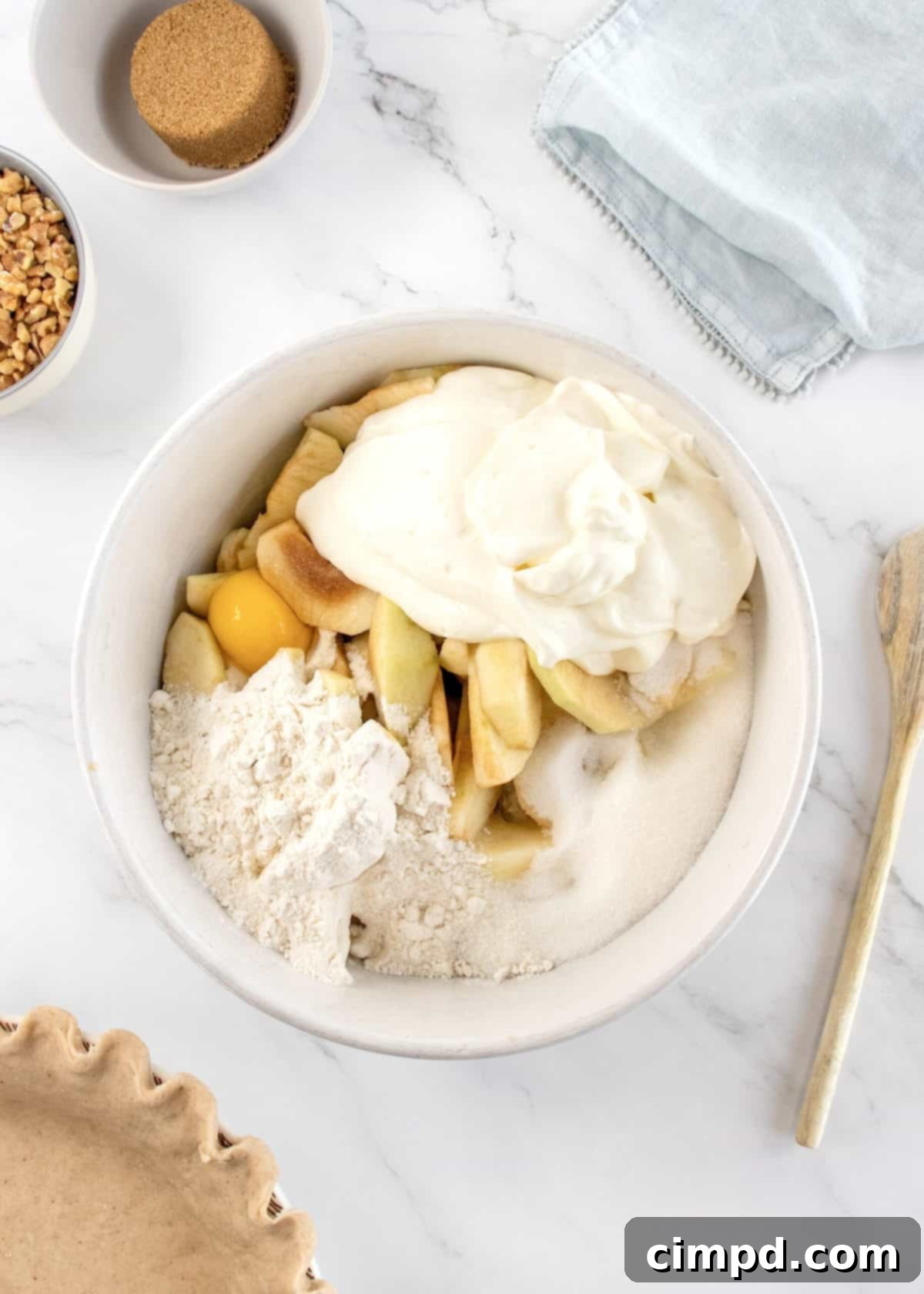 Mom's Signature Apple Pie 6 The apple filling mixture being spooned into the prepared pie crust.