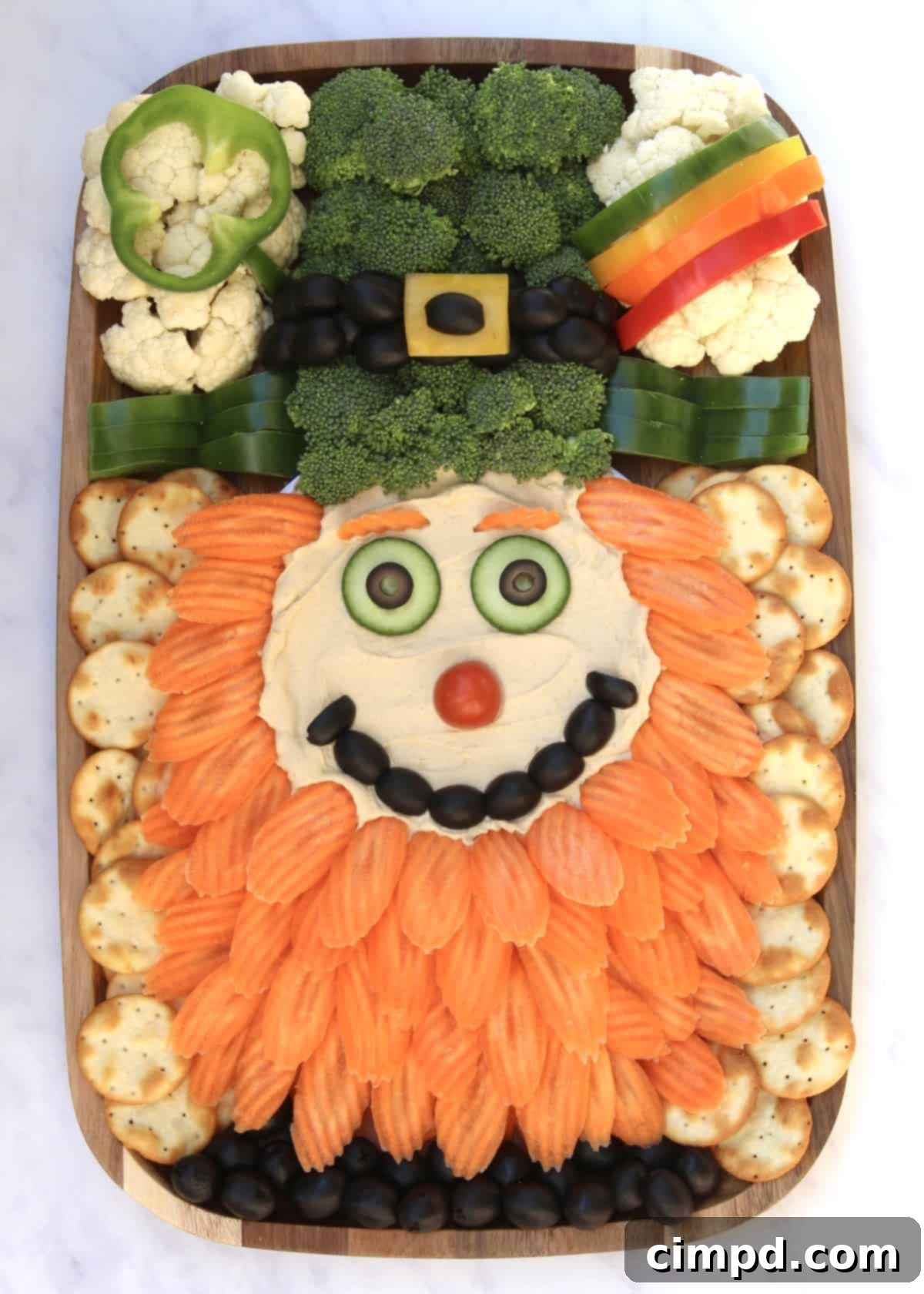 The complete Leprechaun Snack Board surrounded by pita crackers and black olives