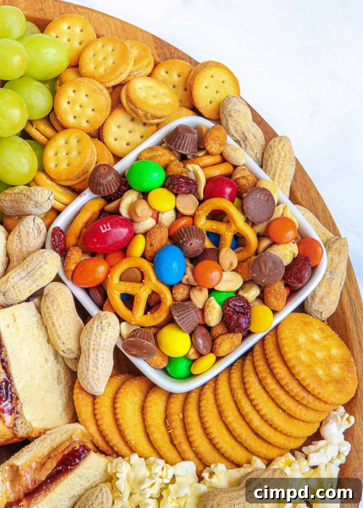 The indulgent side of the PB&J Snack Board, featuring popcorn, crackers, and candy bars.