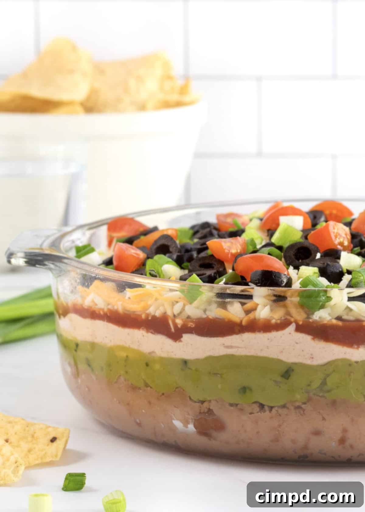 A vibrant, multi-layered 7-Layer Dip, showcasing its various delicious components, ready for serving.