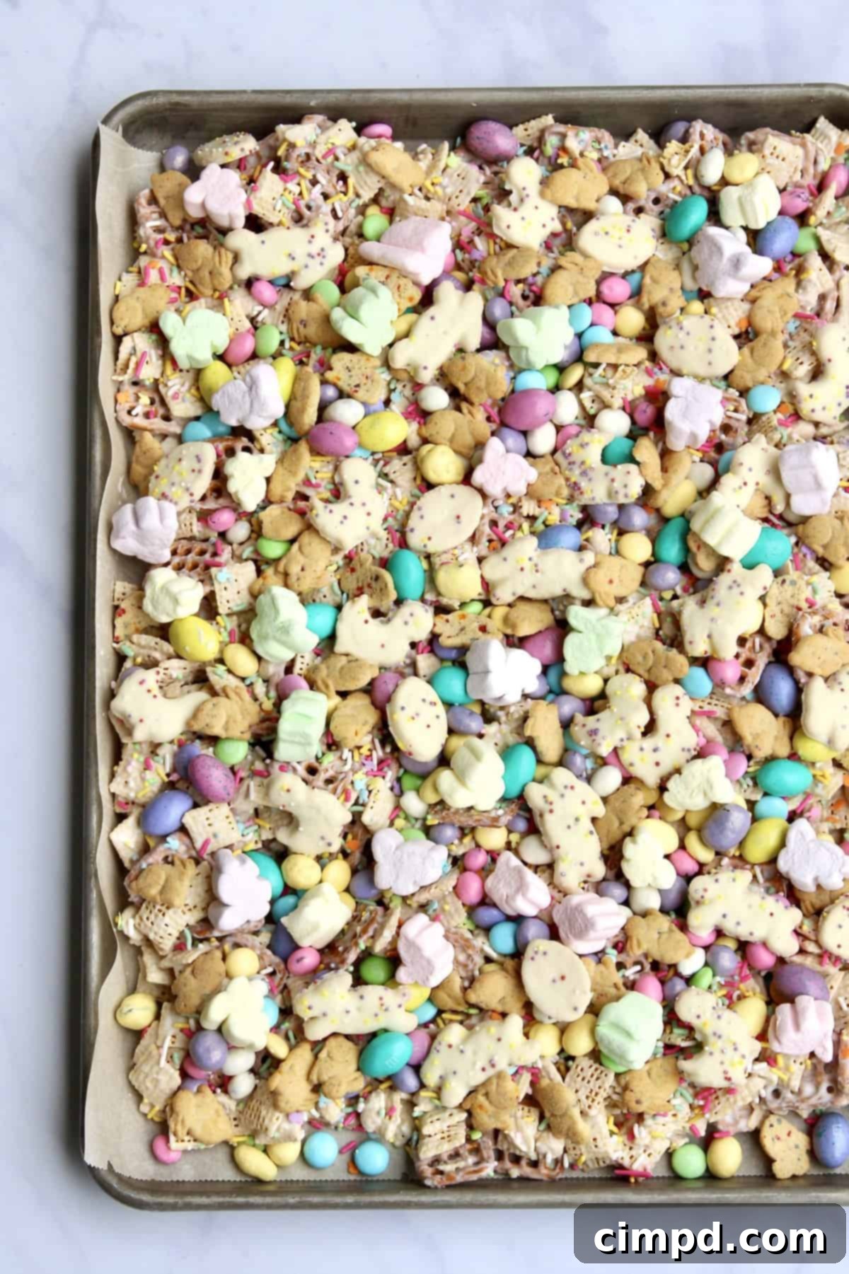 Hoppy Easter Munch 6 A finished batch of Easter Snack Mix spread out on parchment paper, waiting to be broken apart.