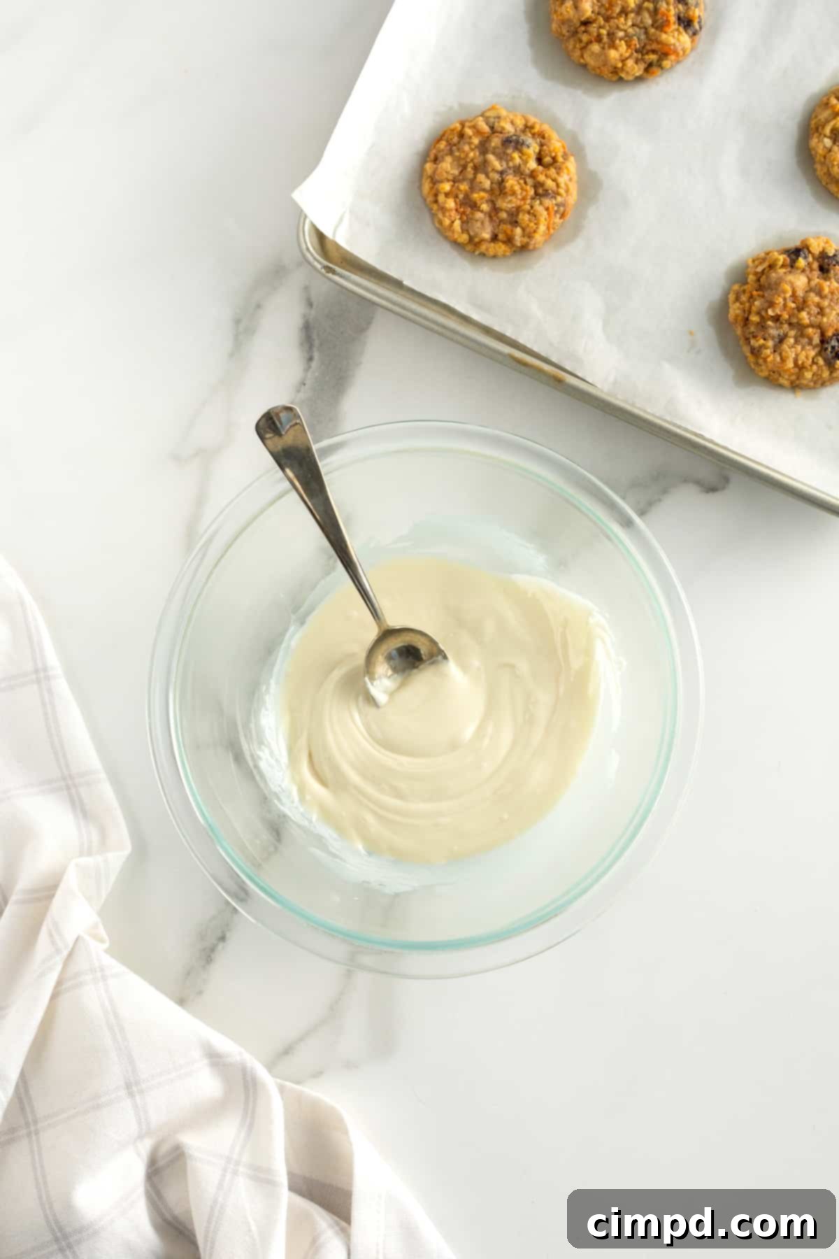 White chocolate being drizzled over Carrot Cake Cookies by The BakerMama
