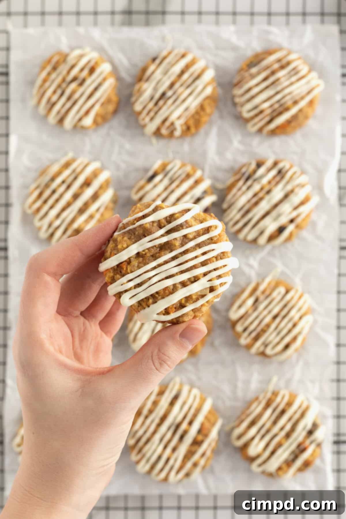 Close-up of Carrot Cake Cookies by The BakerMama, showing texture and white chocolate drizzle