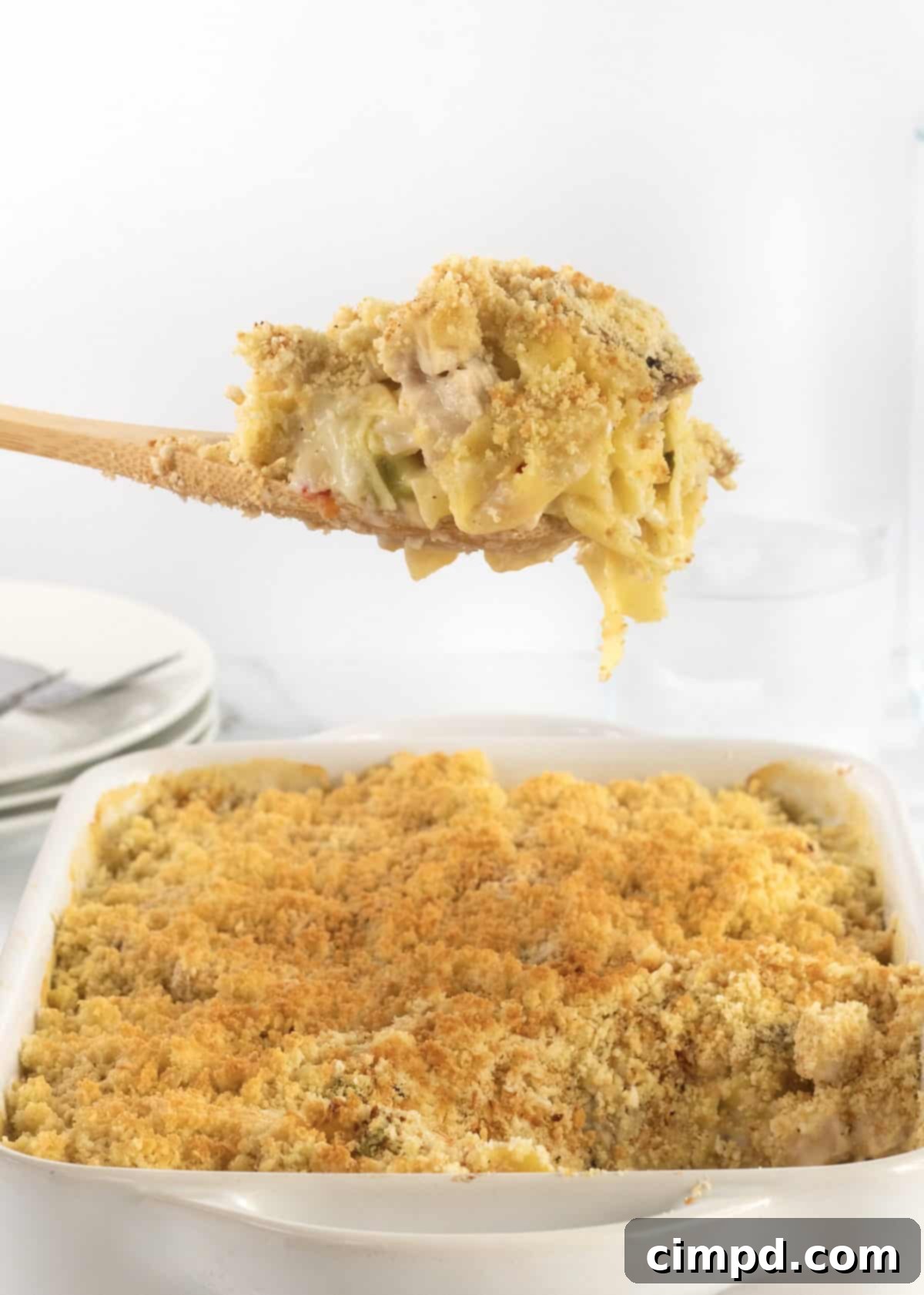 A baked dish of Chicken Noodle Casserole by The BakerMama, featuring creamy noodles and chicken, a perfect comforting meal.