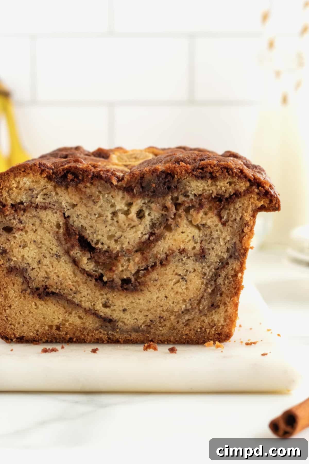 A slice of Cinnamon Swirled Banana Bread on a plate, showing its tender crumb and rich swirl.