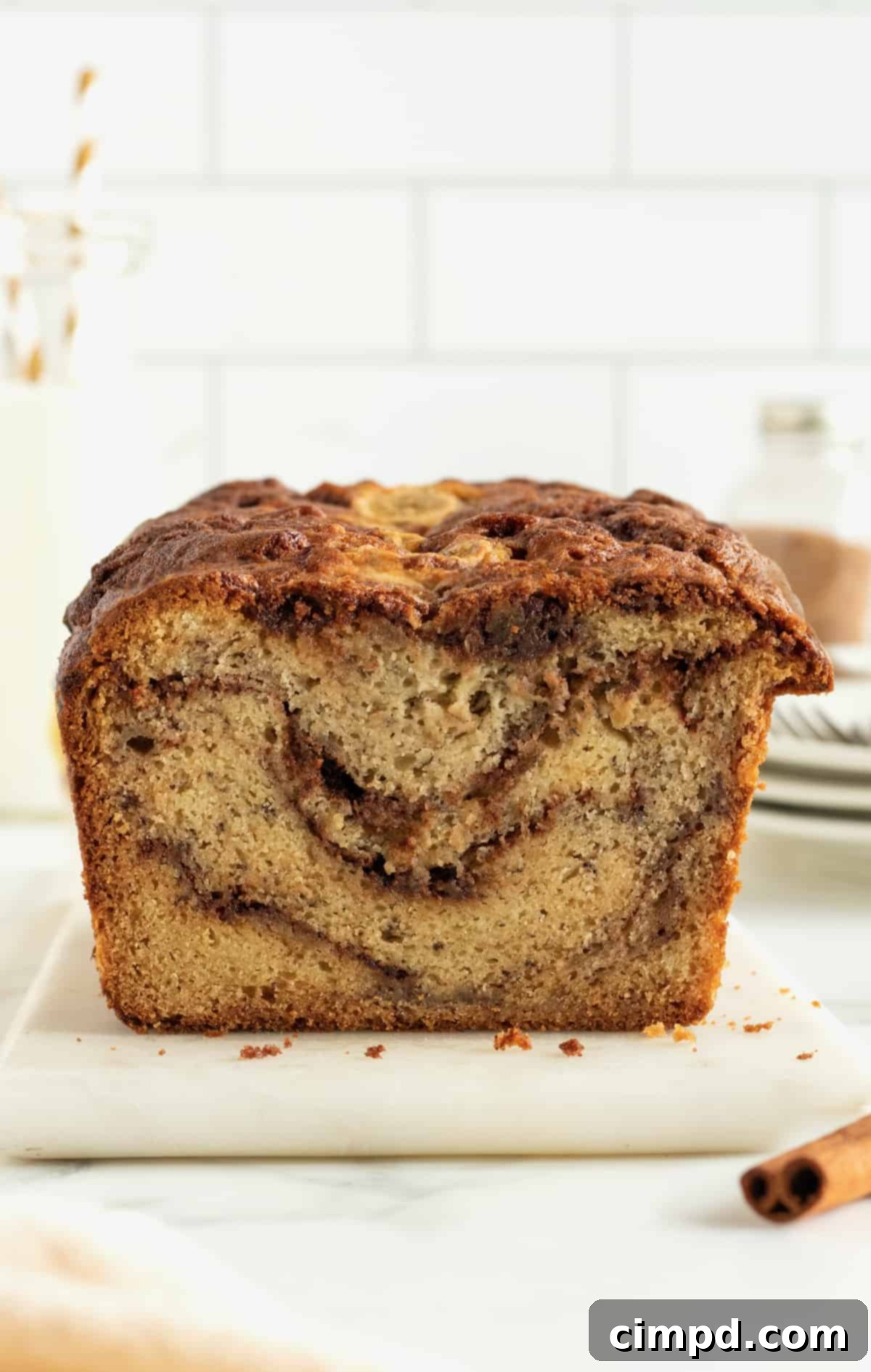 Cinnamon Swirled Banana Bread on a serving board with a knife.
