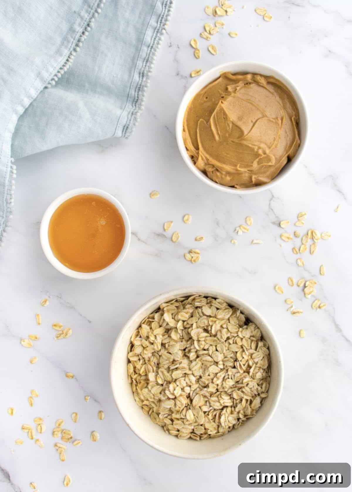 Key ingredients for Peanut Butter Honey Oat Bars laid out: oats, creamy peanut butter, and golden honey.