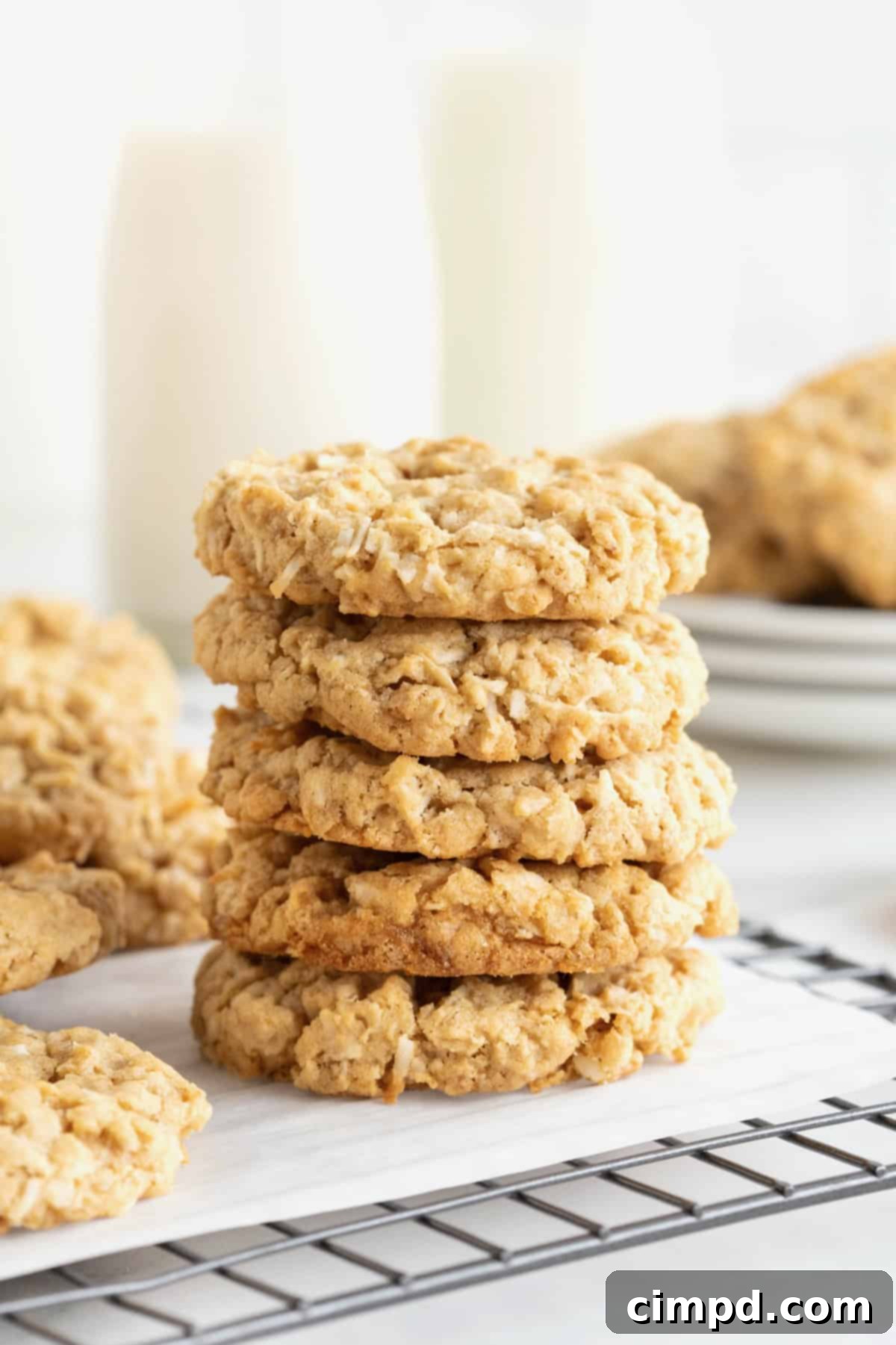 Spiced October Treats 2 A stack of 5 October Cookies on a parchment lined metal cooling rack, with more cookies piled on plates in the background.