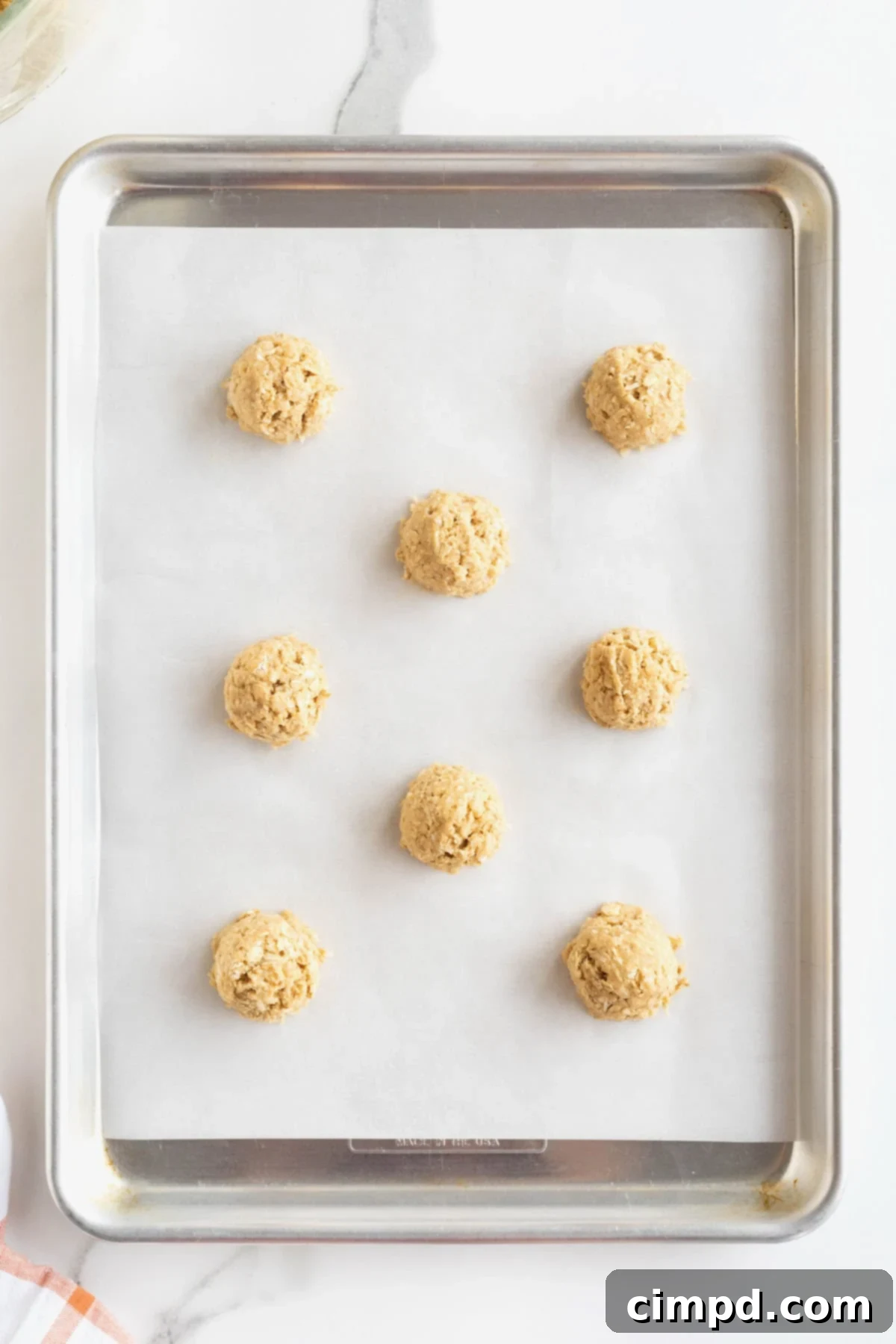 Spiced October Treats 7 Cookie dough balls for October Cookies perfectly spaced on a parchment lined aluminum baking sheet, ready for the oven.