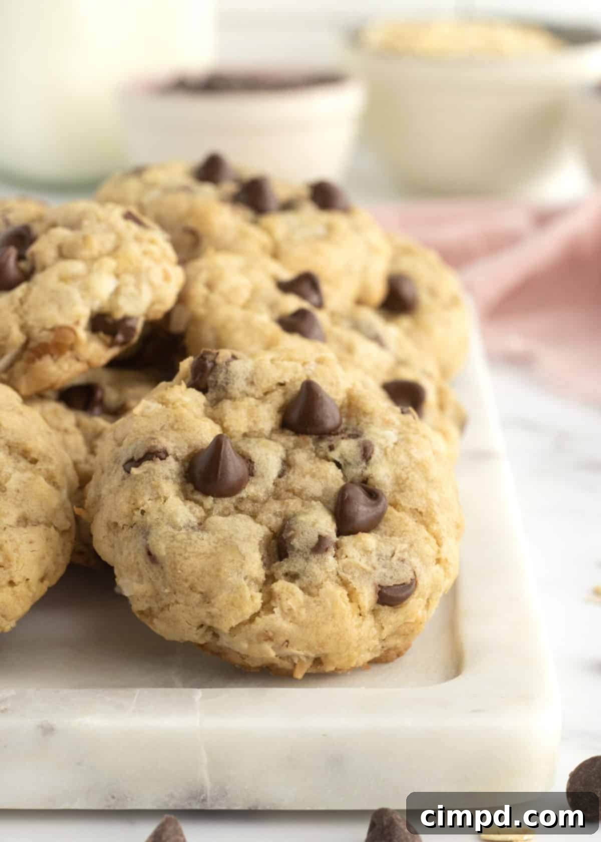 An array of different oatmeal cookies, including Coconut Pecan Chocolate Chip, on a white plate