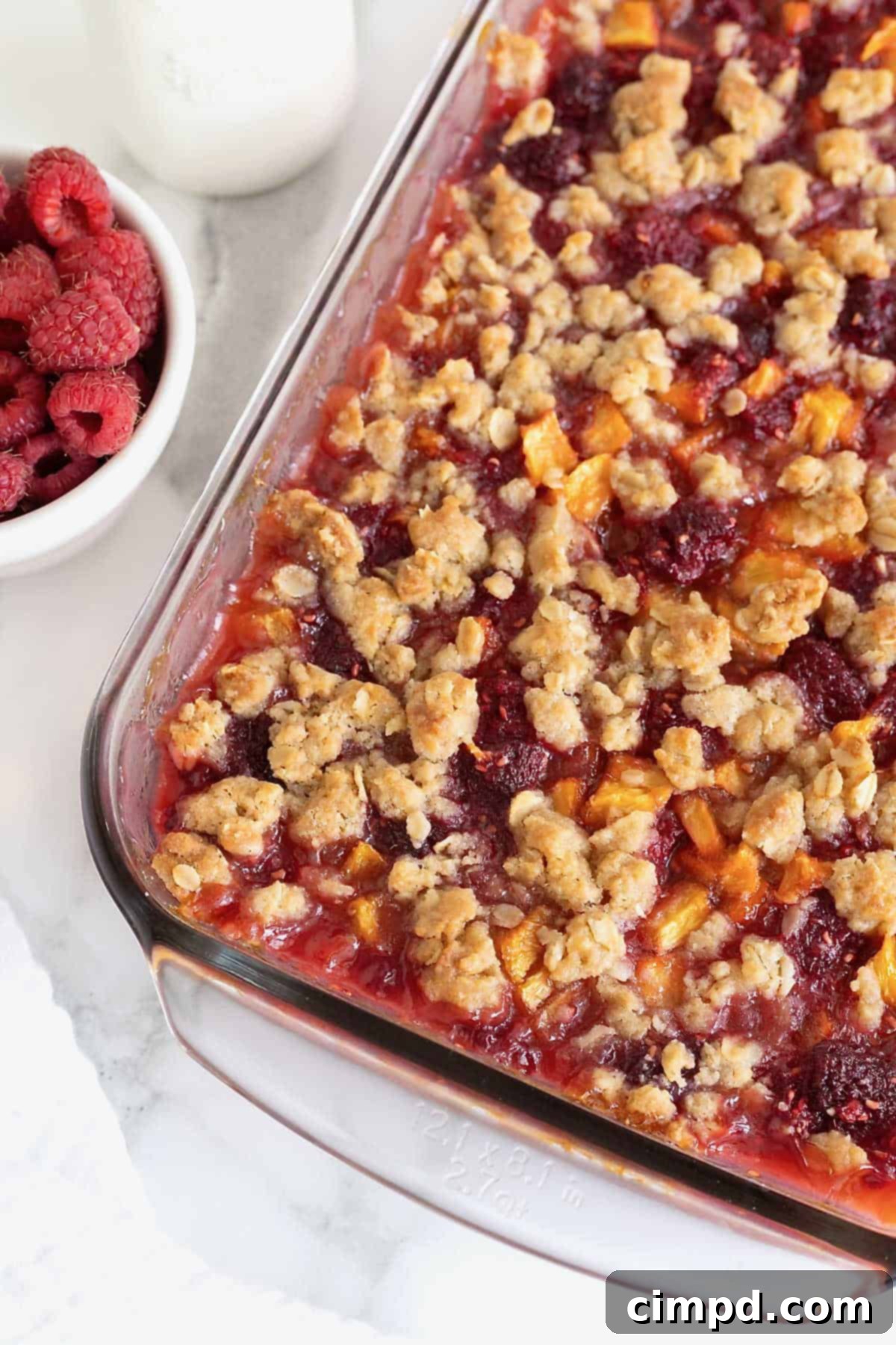Rustic Peach Raspberry Crumbles 4 A glass baking dish of raspberry peach crumb bars.