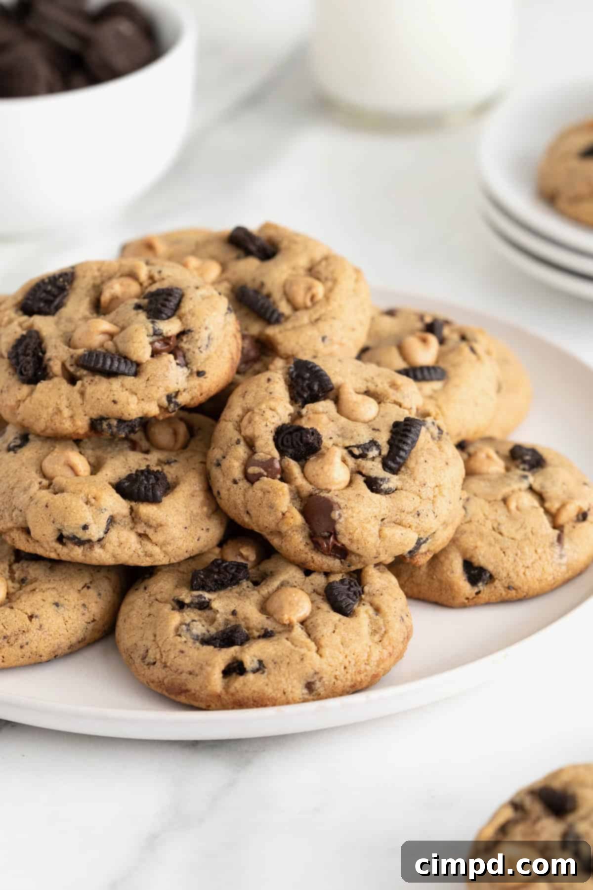 A white platter piled with peanut butter Oreo cookies, showcasing their golden-brown edges and abundance of fillings.