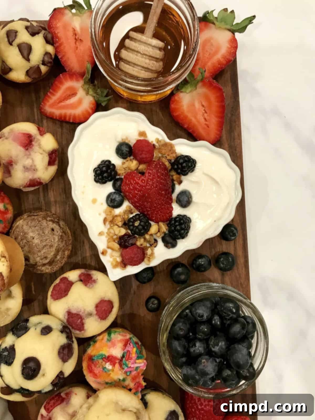 A close-up of a Mini Muffin Board, highlighting the fresh, ripe berries and perfectly baked mini muffins, ready for serving.