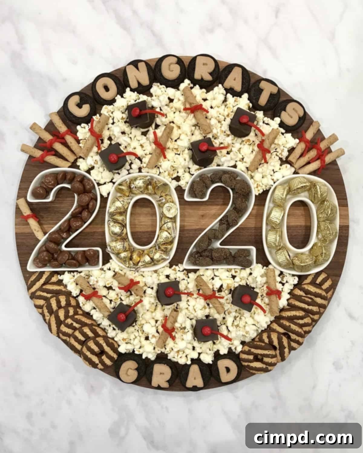 A beautifully arranged Graduation Snack Board by The BakerMama, featuring various sweets and themed treats for celebration.