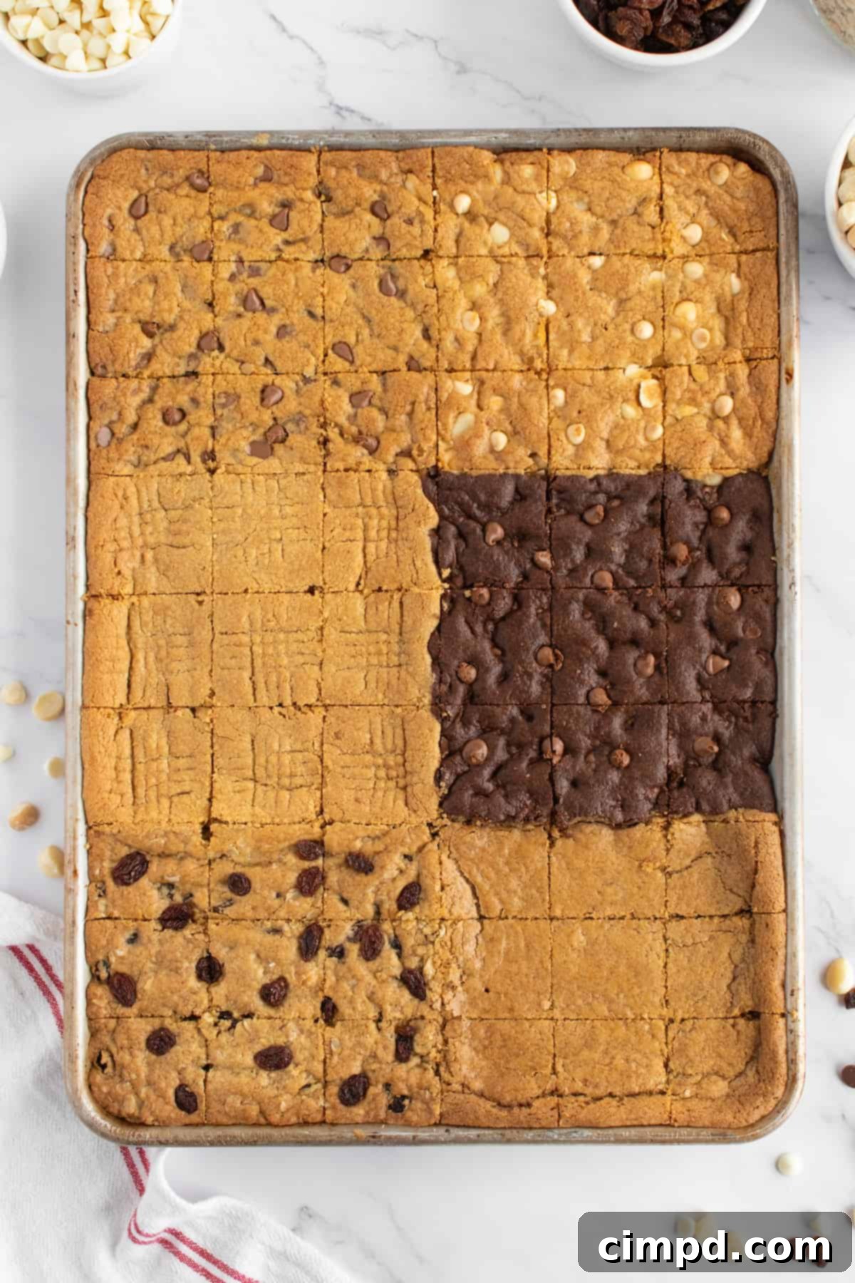 A beautifully arranged sheet pan of six different cookie bar flavors, including chocolate chip, snickerdoodle, peanut butter, white chocolate macadamia nut, oatmeal raisin, and double chocolate chip.