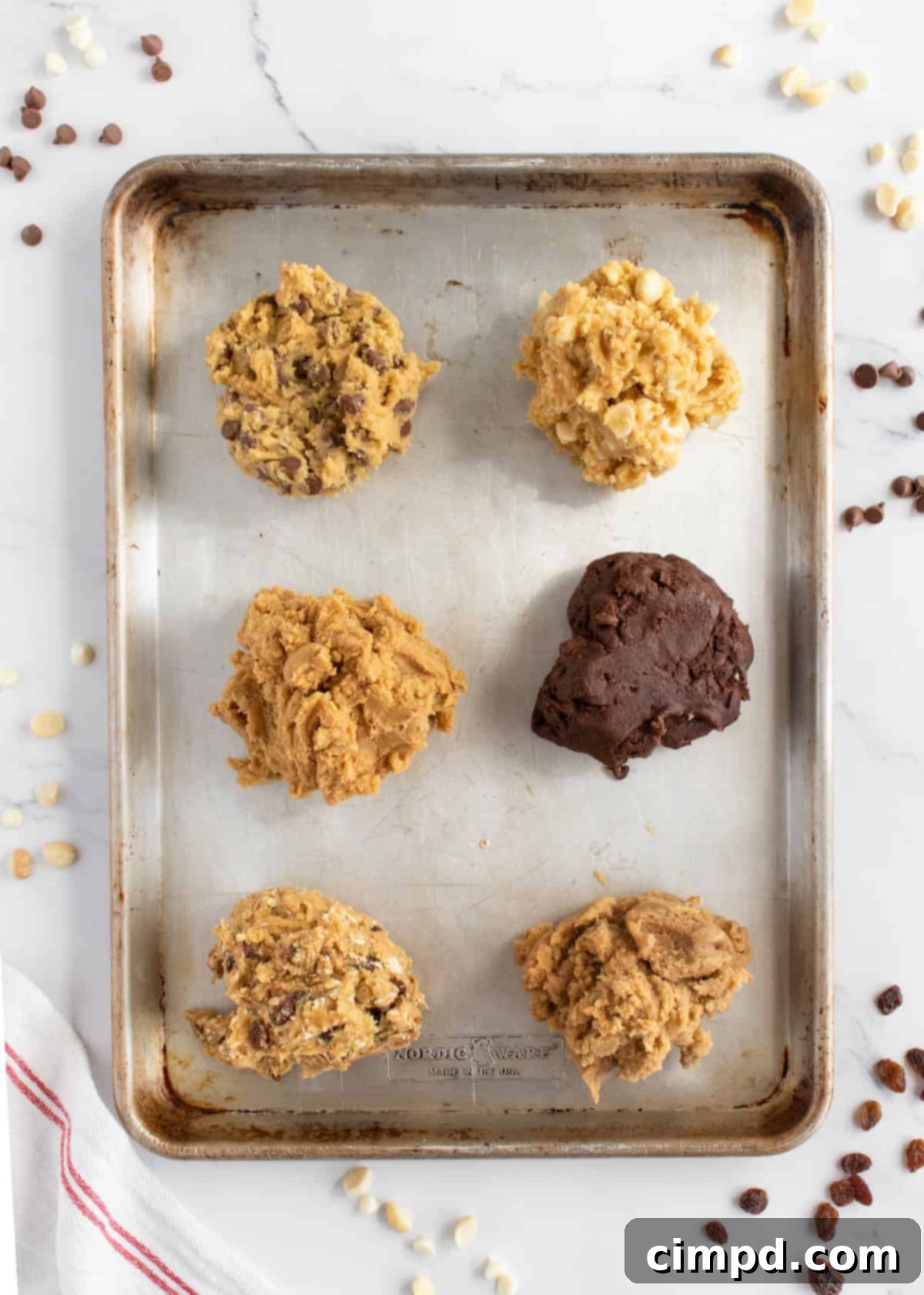 The six distinct cookie dough sections neatly arranged and pressed side-by-side on the sheet pan, ready for final garnishing.