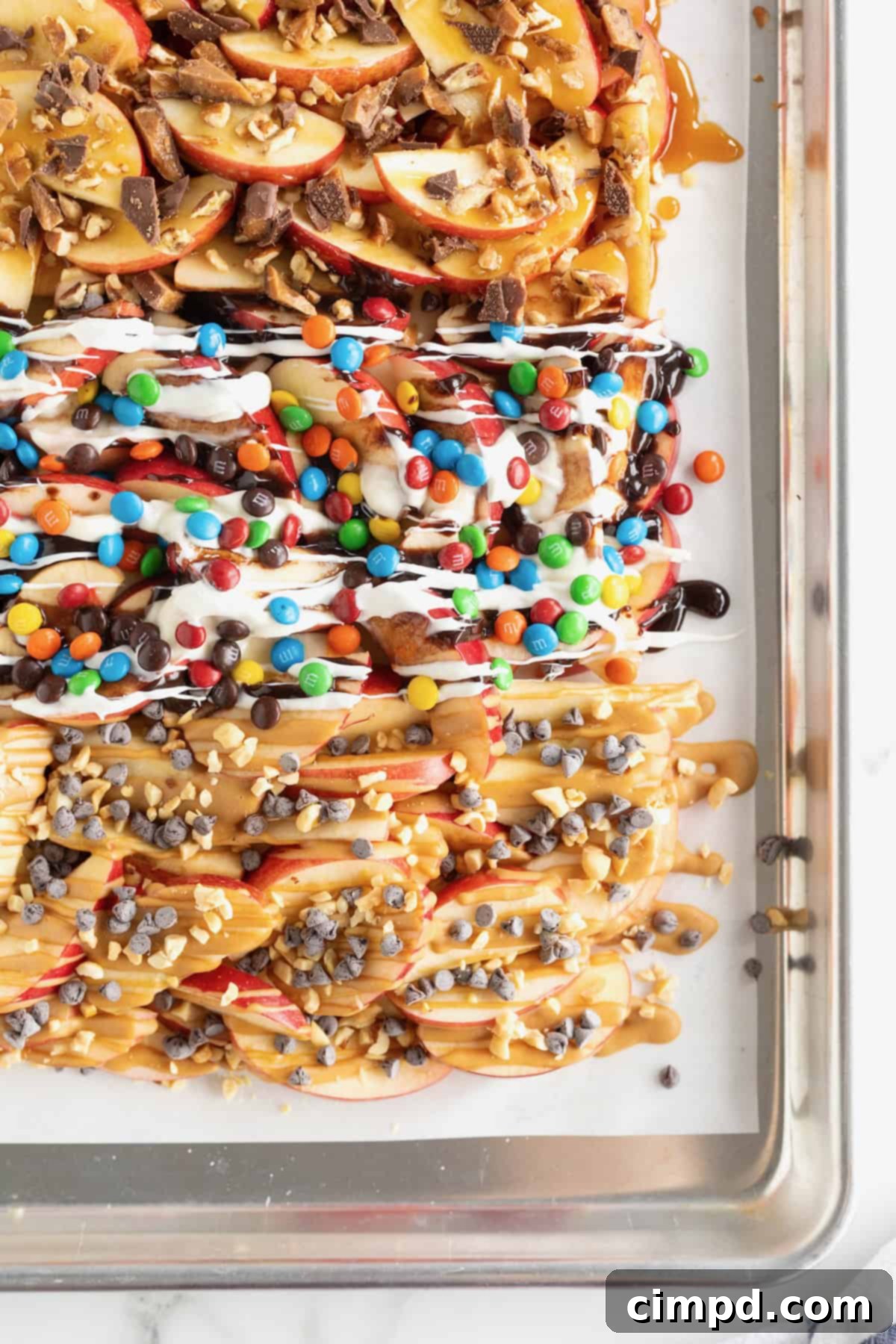 Loaded Apple Slices 10 A parchment lined aluminum baking sheet covered with apple nachos.