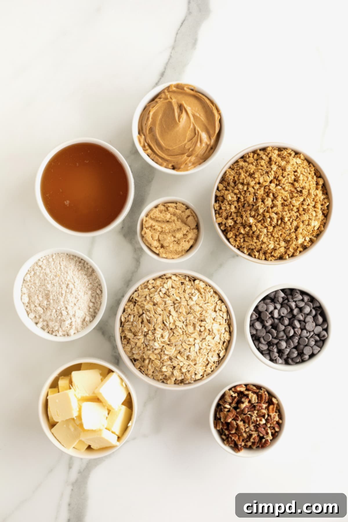 Homemade Chocolate Chip Granola Bars 6 All the ingredients for chocolate chip granola bars in small white dishes on a white marble counter.